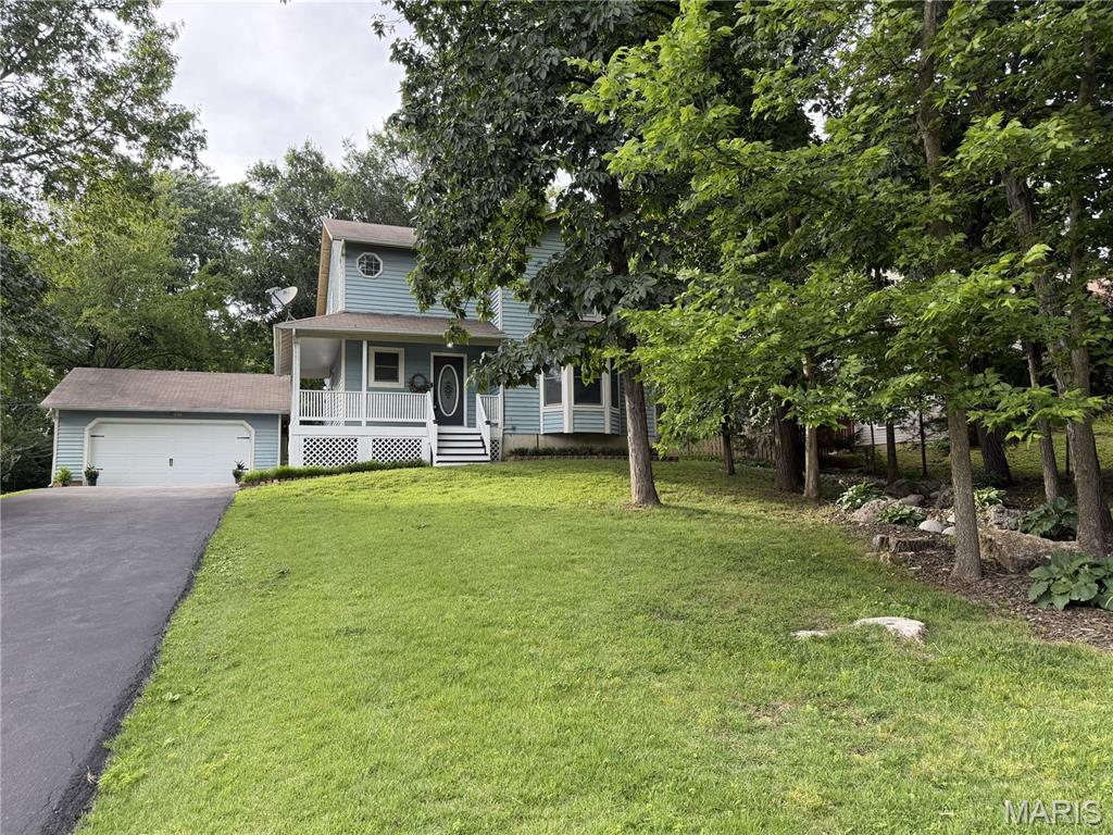 Tucked away on a hill sits this charming 2 story, 3 bedroom 2.5 bath home that features all hardwood floors. The home has a wrap-around porch and a fenced in backyard. Looking up at the house, you will notice the property’s own small wooded area with mature trees. A private, custom, dry river winds around the trees going down the hill in the front yard. From the inside, you enjoy this private, peaceful view through the large bay windows. The property has a long, newly paved driveway leading you to the house’s detached two car garage that has a new garage door. The main floor of the home features a nice sized kitchen with a newer oven, range, dishwasher and refrigerator. The home also has a newer AC and heating system with separate AC units for each floor. The large basement was waterproofed with a lifetime warranty that is transferable to the new owners. The home has a large back deck that leads to a welcoming yard with mature trees, a grassy area and a pebbled area that is surrounded by planters. Don’t miss out on this rare opportunity to own a spacious, beautiful home with its own private wooded area and dry river. Basement is partially finished. It boasts 872 square feet with a laundry/furnace/AC/water heater area, a large storage area, and potential family room/TV area. It also has a Clayton wood burning stove which is hooked into the home ductwork system to heat the home in the winter. There is a vented exhaust pipe to move any wood burning fumes out of the home.