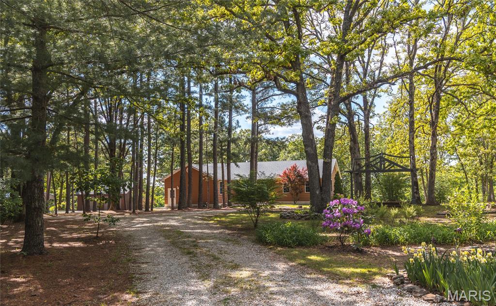 Tucked among mature pine trees on 29.17+/- acres, this property offers a setting that immediately feels removed from the pace of everyday life. The landscape is a blend of open pasture, timber, winding trails, and a wet-weather creek, creating a property that is as enjoyable to explore as it is to call home. Whether it's hiking, riding the trails, tending to animals, or hunting, the land provides something to appreciate throughout every season The home features 3 bedrooms and 3.5 baths. Hardwood flooring runs throughout the upper level, while the finished walkout basement provides additional living space and opens directly onto the concrete patio. The covered deck quickly becomes a favorite place to spend time, offering views across the property and a front-row seat to evening sunsets and the wildlife that filters through. Outside, the property is well-equipped for those seeking a hobby farm or simply a place with room to pursue their recreational interests. The horse barn includes stables and a tack room, while the large shed building provides valuable workspace and storage, two additional rooms, and a lean-to along the back. A detached two-car garage and carport offer ample room for vehicles and equipment. The property is conveniently located approximately 10 minutes from Rolla and within the St. James School District. The full appeal of this property is hard to capture in words alone. Schedule your showing and see firsthand what makes it special.