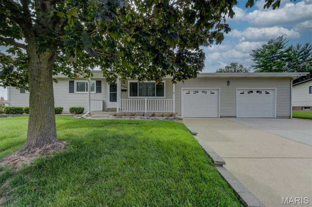 Welcome Home to this spacious 3 bed, 1.5 bath home perfectly positioned on a corner lot with an oversized 2-car garage.   The main level features new carpet in the bedrooms, a comfortable living room, and a family room with a fireplace.  The kitchen offers wood cabinetry with convenient pull-out drawers, along with a gas range, microwave and refrigerator.  The partially finished lower level adds even more living and entertaining space with a bar, second fireplace and half bath. The laundry area also includes a shower for added convenience. Outside, enjoy the level-fenced yard and patio with awning-perfect for extending your living space outdoors. Furnace was replaced in 2018 furnace and the A/C in 2021. With multiple living areas plus an oversized 2-car garage, this home offers comfort and functionality inside and out!