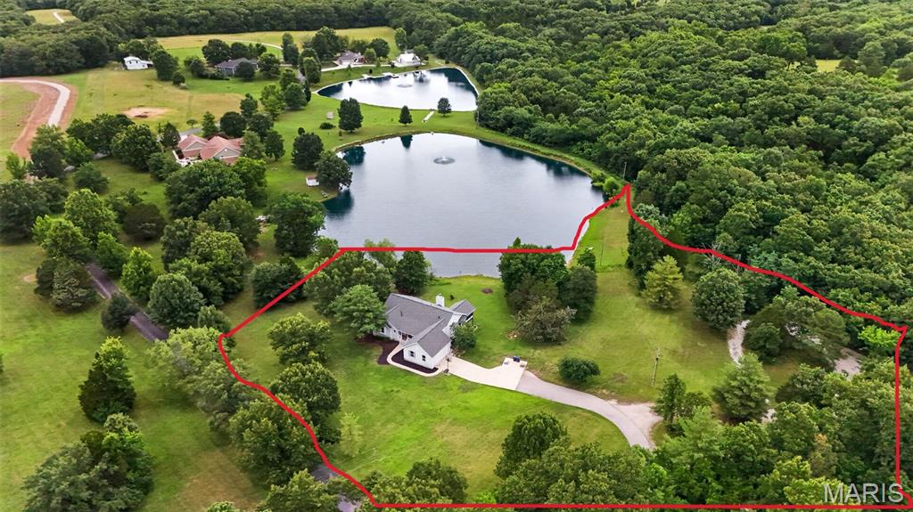 Incredible setting!!! This amazing 4.9+ acre scenic lot offers beautiful lake views, lake access, private cul-de-sac and private road entrance providing so much privacy, yet minutes from city amenities! The beautiful Ranch Home boasts over 3,800 square feet of finished living space with so much to offer!

The main level features 3 bedrooms and 2.5 baths, including a primary suite with vaulted ceilings, bay window, walk-in closet, and private bath with double vanities and walk-in shower. The vaulted great room offers an expansive wall of windows that showcase the lake views and fill the home with natural light! You'll also find a large dining area, open kitchen with breakfast room with large bay window, center island, pantry, main-floor laundry, huge mud room with utility sink and powder room, 2 additional Spacious bedrooms and another full bath! The screened in porch off of the breakfast room provides the perfect place to relax and enjoy the peaceful setting!

The finished walkout lower level offers so much additional living and entertaining space with a brick wood-burning fireplace, huge rec room, an additional bedroom, full bath, bonus room, and plenty of storage!! 

Since purchasing the home, the current owners have completed numerous major improvements, including all new engineered hardwood flooring and carpet throughout, fresh interior paint, well and septic updates to meet current code requirements, and more! Additional major updates include a new roof in 2024 and an HVAC system that is approximately five years old.

Outside, you'll find an attached 2-car garage plus a detached outbuilding with 3 garage bays and a lean-to, providing ample space for vehicles, boats, equipment, hobbies, or workshop space. A private cul-de-sac drive provides convenient access to the detached garage and outbuilding. 

With acreage, lake access, extensive updates, and room to make it your own, this property offers a rare combination of space, privacy, and natural beauty!!  

Bonus ** Current HOA restrictions do not allow for poultry  / chickens - however, association allows them.  Restrictions are in the process of being revised.