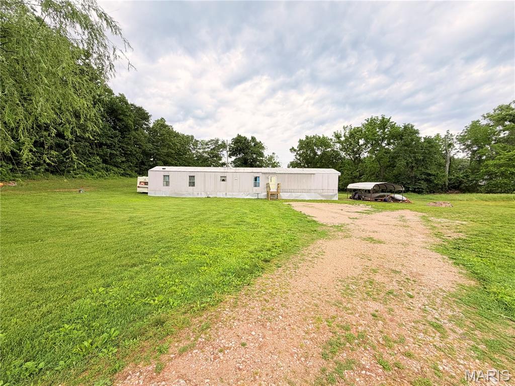 Experience the peace and privacy of country living with this charming three bedroom two bath home nestled on 4.24 acres featuring an open concept layout with a spacious living area, kitchen and cozy fireplace. This home offers the perfect blend of comfort and functionality.
Step outside and enjoy   mostly fenced pasture ground with beautiful, wooded property lines in a serene creek flowing through the land, creating the perfect natural setting for relaxation and outdoor enjoyment. A nice storage shed with a concrete foundation provides plenty of space for equipment, tools, and hobbies while the carport adds everyday convenience.
If you’ve been searching for privacy, nature and room to roam without sacrificing convenience, this property is a must see, located just approximately 15 minutes from town and local amenities. You can enjoy the quiet country lifestyle while still being close to everything you need. Don’t miss out on this opportunity schedule your private showing today.
