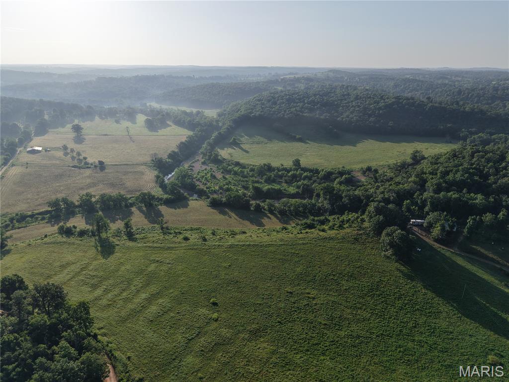 Live water flows throughout this sprawling 190 Acre Farm. With 2 year round creeks and 3 ponds your livestock and wildlife will have no lack of water! Whether you are looking to cut hay for your own animals or sell hay for extra income there are about 75 acres of quality hay ground out of the 125 open acres. The property has a large hay barn with included working and holding pens along with a cattle chute. Nearly all of the property border is fenced with cross fenced pastures throughout. If you are interested in hunting the property is thick with deer and turkey along with other wildlife such as bald eagles, beavers, and blue herons. The mixture of pasture and woodland makes for great wildlife habitat and the property abuts Corps of Engineer land to the south. There are several areas that would work well for food plots. The 3 bedroom 2.5 bath house is partially finished and ready for the new owner to finish with their own touches. With a spacious open floor plan and vaulted ceilings this home has plenty of space. Lots of extras are already in place such as high end cabinets, a new 5 unit mini-split, ample insulation, new Anderson windows, a plumbed steam shower in the master bath, and 320 amp electric service. There is a huge 30x60 shop with oversized electric garage doors and a concrete floor. The well and septic system are in place along with 2 chicken coops, raised garden beds, and a mini orchard with cherry, apple, and peach trees. This property has so much to offer and is very close to the Mark Twain National Forests and the Clear Rivers of the Missouri Ozarks. Call today to see this unique property!