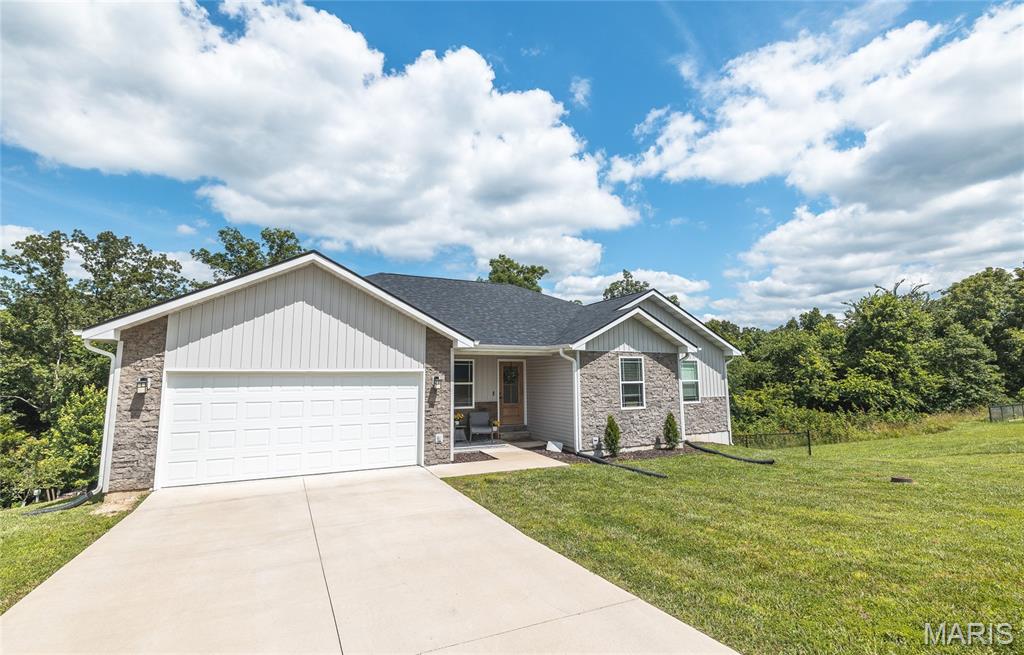 Discover the perfect blend of privacy, craftsmanship, and convenience with this beautiful custom-built home located just minutes from town in a quiet, secluded subdivision in Rolla, Missouri. Nestled against a wooded backdrop with a peaceful creek, the private backyard offers a serene setting to enjoy nature from the multiple covered porches and outdoor living spaces on different levels. Inside, you'll find an open-concept floor plan featuring soaring vaulted ceilings, stunning custom trim work, and a one-of-a-kind tree bark ceiling that adds rustic character and warmth. The spacious kitchen is equipped with stainless steel appliances, a breakfast bar, and flows seamlessly into the main living area, making it ideal for entertaining. The luxurious primary suite showcases a coffered ceiling and a beautifully designed custom bathroom, creating a relaxing retreat. A second living room provides additional space for family gatherings, a recreation room, or home office. The home also features a two-car attached garage and two large unfinished storage rooms, offering endless possibilities for expansion, hobbies, or abundant storage. If you're looking for a quality-built home with unique custom features, exceptional outdoor living, and a private setting just minutes from all the conveniences of Rolla, this property is one you won't want to miss.