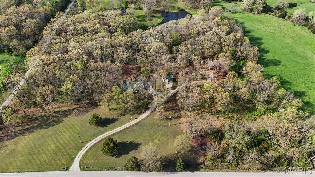 Looking for land, privacy, and the freedom to create your own space? This 10-acre property near Warrenton, with convenient access to I-70, offers a rare opportunity to own a mix of wooded ground, open space, and a peaceful pond setting all in one.

As you arrive, you will notice the natural privacy this property provides. Approximately 75 percent of the land is wooded, giving you shade, seclusion, and a true country feel, while the remaining open ground offers usable space for animals, gardening, recreation, or future plans. The pond adds to the setting and creates a quiet place to relax, fish, or simply enjoy the outdoors.

This property is well-suited for those looking to bring animals or start a small hobby farm. With some existing fencing and a history of horses on the property, there is already a foundation in place for livestock, 4-H projects, or your own rural lifestyle. Whether you are thinking about goats, chickens, or other animals, there is room here to make it happen.

In addition to the land, you will find a large metal outbuilding that offers excellent space for equipment, hobbies, storage, or a workshop. Two additional sheds provide even more flexibility, including one that could serve perfectly as a gardening shed or workspace. The combination of buildings gives you the ability to organize tools, supplies, and projects without sacrificing space around the home.

The home itself is a 3-bedroom, 2-bath residence with 1,568 square feet, set on a permanent foundation and built in 1995. Inside, the layout features a large open main living area and a split-bedroom floor plan, offering separation and privacy for the primary suite. There is also a main floor laundry for everyday convenience.

The home does need updating and is ready for your vision. With new flooring, paint, and remodeling, this space can be transformed to match your style and needs. For buyers looking to build in the future, this property offers the option to live on-site while you plan and construct your next home. It could also serve as a long-term rental or additional living space down the road.

Properties like this are getting harder to find. Ten acres with a mix of woods and open ground, a pond, multiple outbuildings, and the ability to create your own setup do not come along often. Whether you are looking for space to spread out, a place for animals, or a property with long-term potential, this one is worth a closer look.

If you have been waiting for the right piece of land with opportunity, flexibility, and a peaceful setting, this property is ready for its next chapter.