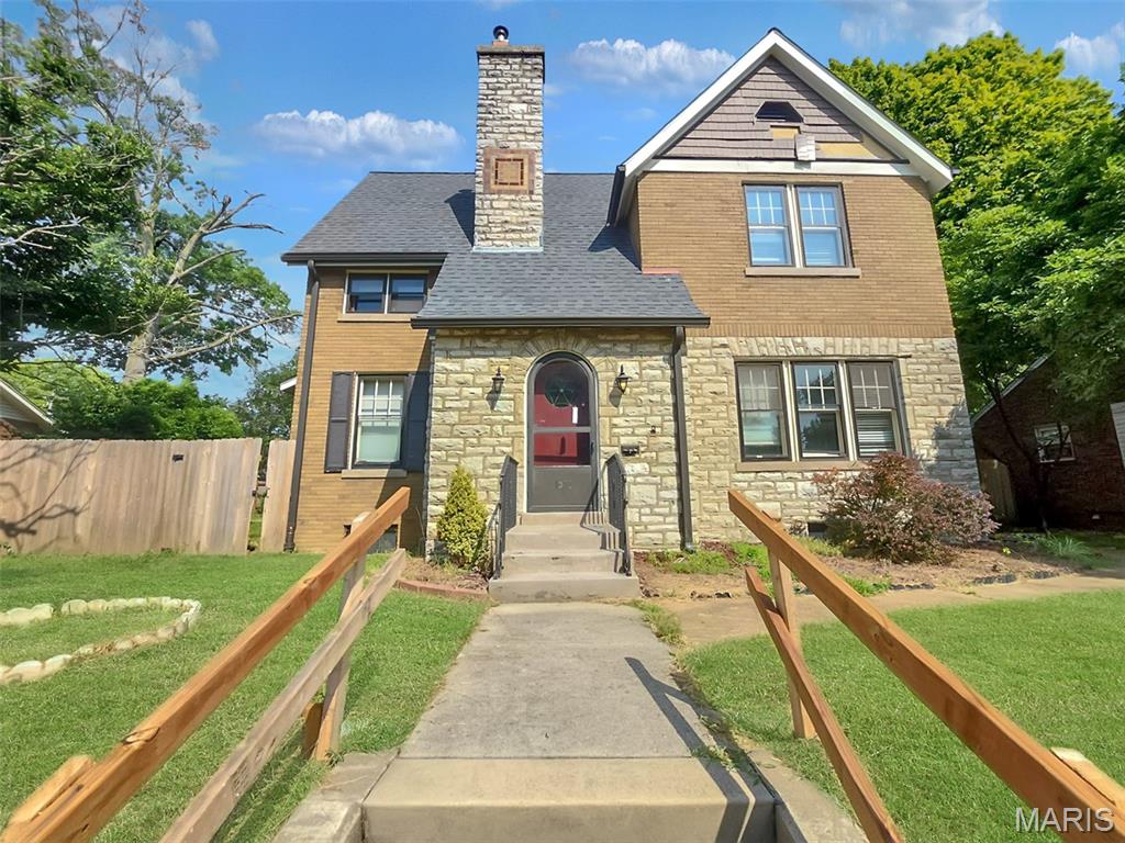 Featuring traditional brick and stone exterior masonry, this four-bedroom, two-bath residence offers over 3,200 total square feet of living space. Highlights include an entry foyer, main-floor family room with original terrazzo marble flooring and a wood-burning fireplace, formal dining area, cozy kitchen, and a main-level bedroom and full bath. Three additional bedrooms and a second full bath are located upstairs, while the partially finished lower level provides bonus storage space. The spacious lot includes an attached garage, additional off-street parking, and a private rear patio.