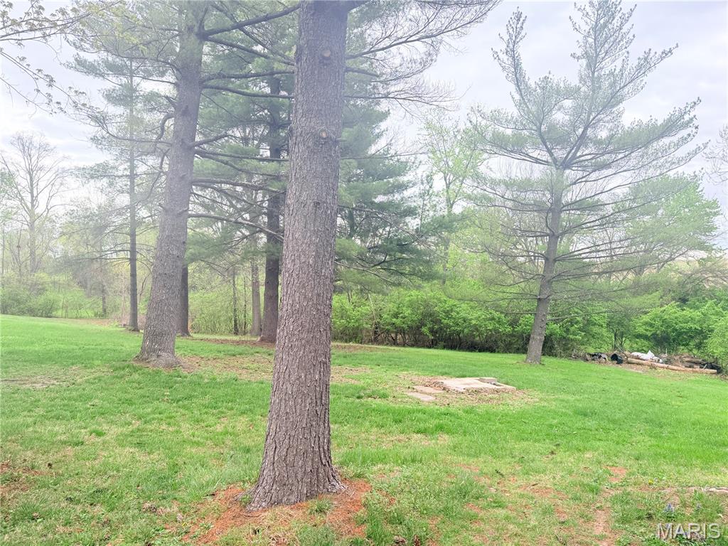 Opportunity awaits on this five-acre corner parcel with a pond, creek, and mature trees. The 1890 home requires substantial renovation and is being sold as-is. Ideal for contractors, investors, or buyers with construction experience seeking a restoration or redevelopment project. The home reflects its age and will need significant repairs but offers so much potential. The property features a mix of open space and established trees, providing flexibility and privacy. Pond and creek enhance the setting. Buyers and buyers agent to verify condition, zoning, utilities, and permitted uses.