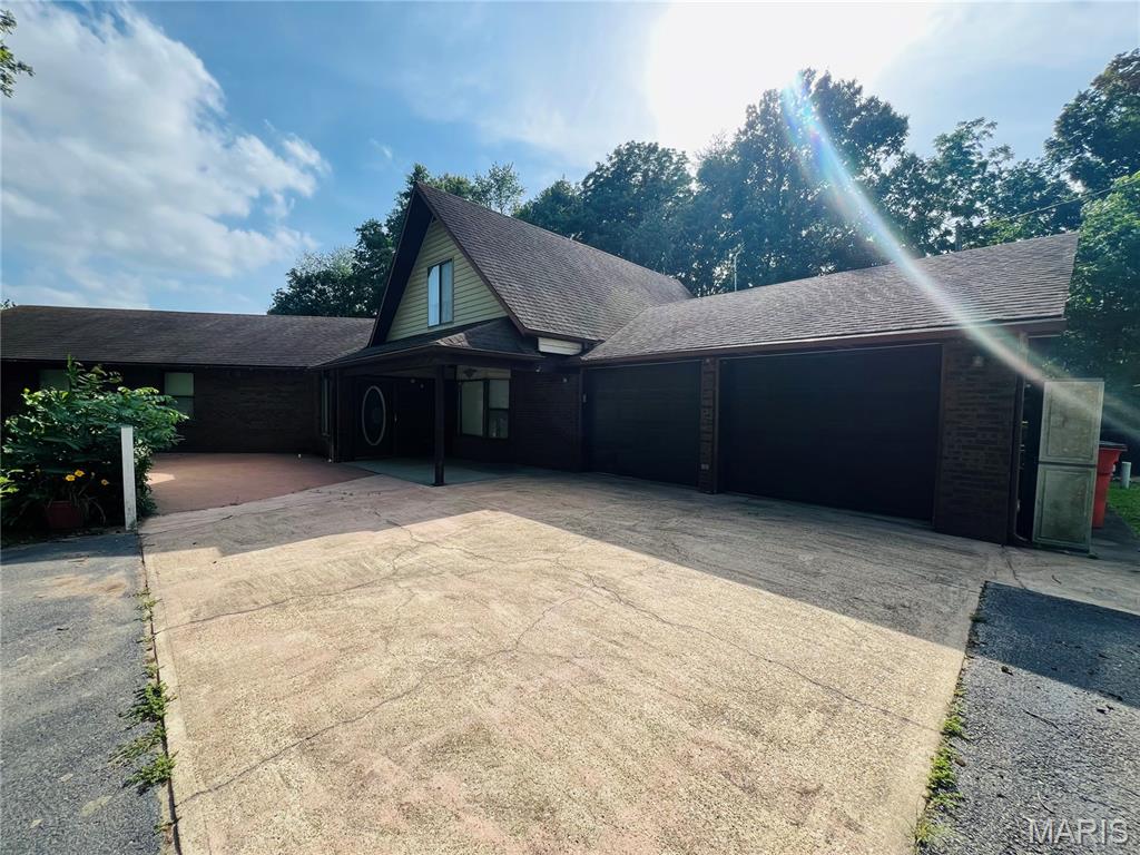 Take a look at this unique, spacious, partial earth home with a large kitchen boasting ample cabinetry and counter space and large dining area to host your family gatherings! Off the dining room is a full bathroom and nice sized utility room with access to the attached 2 car garage. The living room is open with a large bay window and metal spiral stair case leading to an upper bedroom, bathroom and bonus room! Off the kitchen is another full bath with jetted tub and a large bedroom with walk in closet and a his & her closet! Through the foyer is an additional bonus room with small kitchenette perfect for a family room/entertainment room! This home is ready to welcome your family, giving a beautiful, large yard with a front patio, back deck and 2 storage sheds!