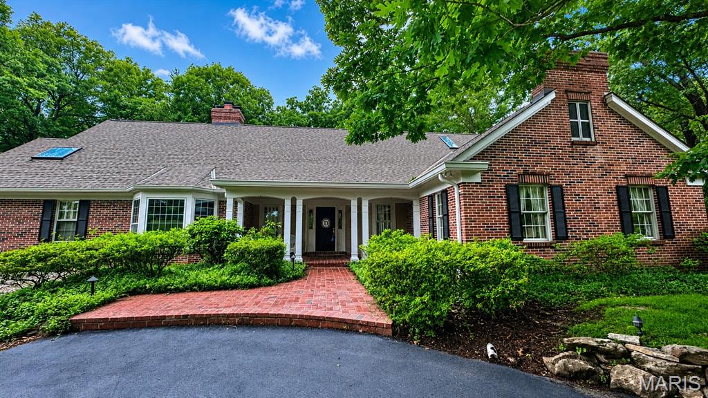 Tucked away on a serene and lushly landscaped lot in Sunset Hills, this custom-built Cape-Cod inspired 1.5 story executive residence offers an exceptional blend of sophistication, comfort, and enduring style. Timeless architecture and casual elegance define this home, highlighted by a stunning main-floor primary suite with luxurious spa-like bath, custom walk-in closet, and adjoining office boasting a box-beamed ceiling, bay window, and fireplace flanked by built-in bookcases. Meticulous attention to detail courtesy of its original owner’s design, the home features generously-sized rooms and tall ceilings, beautiful windows and mill-work, gracious entertaining spaces, a formal dining area, well-equipped chef's kitchen, and oh-so-chic sunroom with mirrored wet-bar and French doors. Handsome brick patios overlook enchanting perennial gardens perfect for outdoor enjoyment, while the light-filled lower level with mini kitchen and entertaining spaces make gatherings effortless. From sunrise to sunset, this home is truly unforgettable.