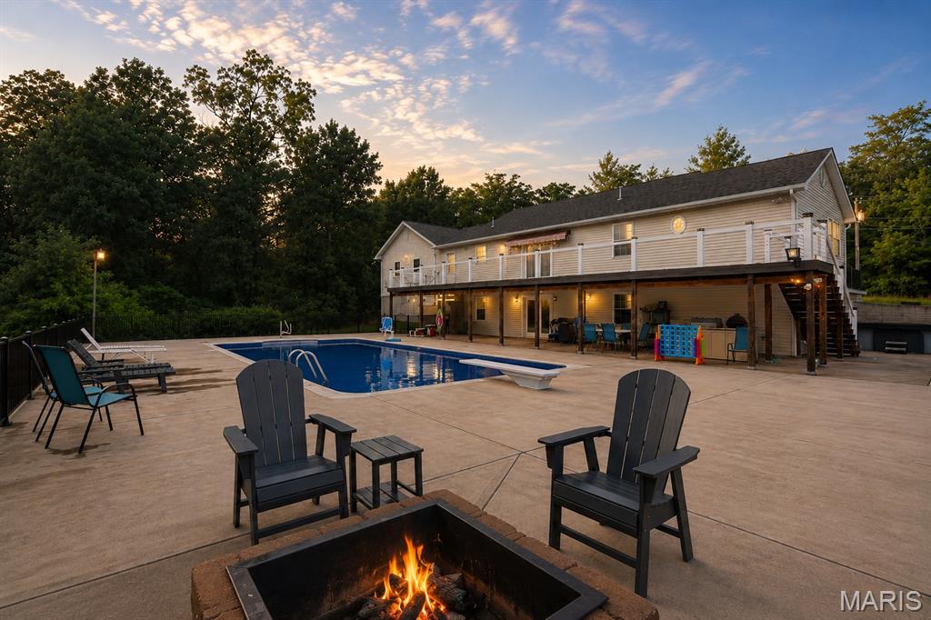 Imagine ending your day floating beneath a canopy of stars, unwinding by the glow of the fire pit, and enjoying the peace and privacy of your own backyard. Situated on approximately 6.3 wooded acres, this spacious ranch-style home offers over 2,700 sq ft of finished living space with 3 bedrooms, 3 bathrooms, and a finished walk-out basement.

Step outside and discover the true showstopper—a beautiful saltwater in-ground pool complete with diving board, expansive concrete decking, fire pit area, and multiple spaces indoors and out for entertaining family and friends. The oversized composite deck overlooks the pool and wooded backdrop, creating the perfect setting for relaxing evenings or weekend gatherings.

For those needing garage, workshop, or storage space, this property delivers. In addition to the attached garage, you’ll find two detached outbuildings offering approximately 6 garage spaces, including a tall overhead door ideal for storing a motorhome, RV, boat, camper, trailers, recreational vehicles, or hobby equipment.

The finished walk-out lower level provides additional living space, sleeping area possibilities, and direct access to the outdoor entertainment areas. Enjoy the privacy of a wooded setting while remaining just minutes from historic downtown Farmington, shopping, dining, schools, and everyday conveniences.

Properties offering acreage, a saltwater pool, finished living space, extensive garage capacity, and RV/boat storage are hard to find. Schedule your private showing today.