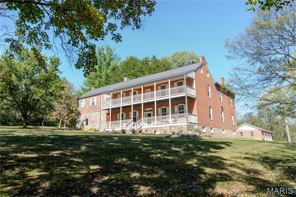 A rare opportunity to own a piece of history, perfectly reimagined for modern living. Step into timeless elegance with this meticulously restored 1860s estate, where historic character and modern refinement intertwine. This distinguished residence stands as a testament to enduring craftsmanship and sophisticated living. This stunning historic home all started with George L. Busch and later owned by Gordian Busch who were well-known by the Washington community. It was referred to as Cedar Grove Farm and built pre-civil war. The property offers over 10 private acres, a gated driveway, a 48ft covered front porch, and a 48ft covered upper level balcony. Inside you will find a true chefs kitchen complete with custom cabinetry, a main level primary bedroom as well as a second floor primary bedroom. This home offers 10ft ceilings and the floors are believed to be original hardwood floors. Downstairs you will find one of the most unique spaces-once styled like an old-world wine cellar, now transformed into an upscale entertainment space complete with a bar, theater room, and bathroom. Outside you will enjoy the gated 7ft in-ground pool that includes 2 bubblers and tanning ledge. Right next to the pool sits the old smokehouse and summer kitchen that were used by the Busch family. Right around the corner is a usable renovated outhouse. You will also find the charming stable with a balcony that overlooks the outdoor horse arena. The stable is equipped with water, electricity, and sewer. Across from the stable you will find the 3 horse stalls fully equipped with a tack room, water, and electricity. This property has 3 separate fenced in areas. The home is perfectly situated in the center of the property providing it with privacy and easy access to all the amenities it has to offer. While this home offers the luxury of privacy, land, and tranquility, it is also located only 10 minutes from downtown Washington and 9 minutes from Borgia, a highly sought after private school. There is truly an abundance of charm and character to this property that you will not find anywhere else.