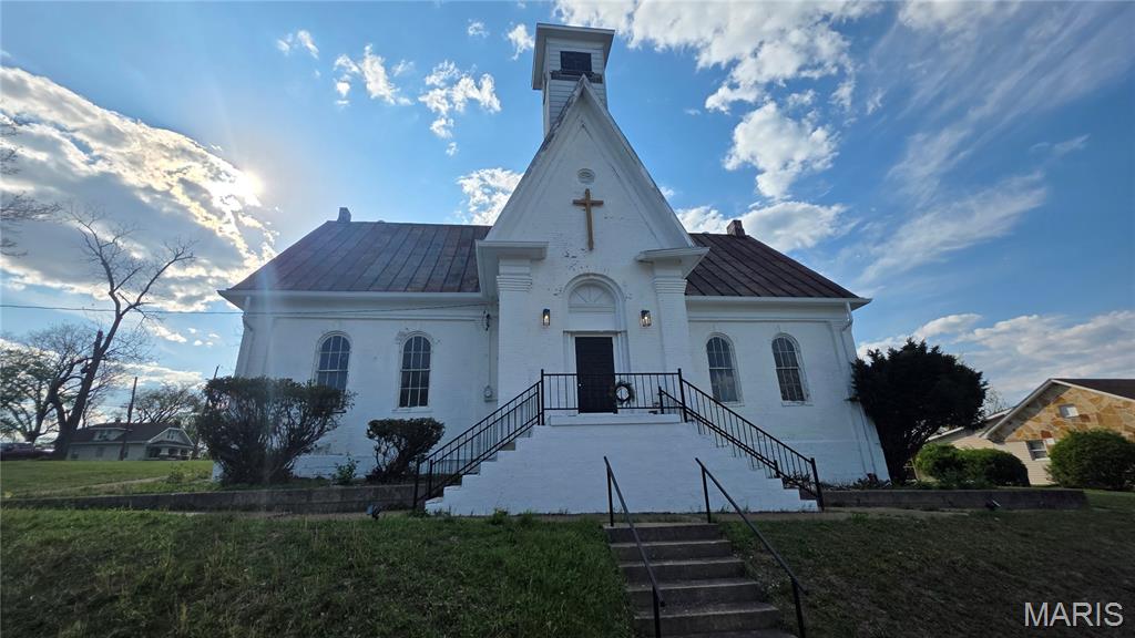 Steeped in history, this 4,095 square foot commercial property is a truly unique offering. Originally an 1866 schoolhouse, later a cherished church, it boasts gorgeous American Vernacular architecture with a modest classical feature-corner pilasters. The ornate original sanctuary lighting has been restored along with a significant restoration of the whole space to preserve the historical quality. The versatile layout includes the adjoining annex built in 1964, and is complete with a large fellowship hall, a kitchen, and two additional rooms. The property comes with two basements, one under the historic school-sanctuary, and the second one is under the annex, great for storage. Both have egress access from outside. Situated on a corner lot with a vacant lot immediately at the corner where once stood a 2-story house. Its basement foundation is covered over and could be used for a future living quarters or office. This property provides an exceptional commercial opportunity in the heart of downtown De Soto.