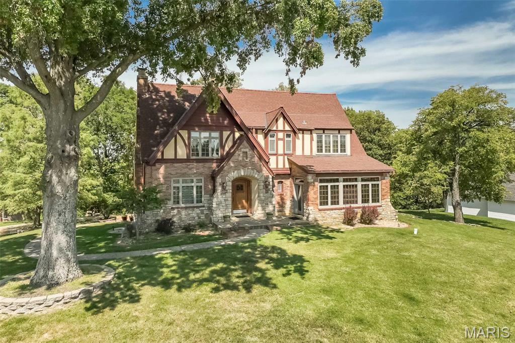 Historic character combines with incredible views, 4 sides brick and stone! This amazing home, built in 1932, was the original estate for what is now Chateau De Parc. Reminiscent of St Louis Hills or Old Webster, there is a sweet timelessness to this property, with hardwood flooring, art glass windows, solid wood doors, turned stairway, light filled formal living room with beams and a masonry fireplace. Formal dining for memorable meals. Kitchen has granite counters, center island, opens to a morning room you will treasure!  Main floor office with 2 walls of windows. Gleaming hardwood upstairs with  3 large bedroom and 2 full baths. This home is positively spotless and the love it's been shown is around every corner! True to a European tradition, a second full kitchen in the basement ensures the ability to host a crowd.  The expansive patio affords inspiring views and features an authentic pizza oven to be enjoyed year round. New interior paint '26! Timeless quality, this is a rare opportunity! Located in the desirable Lindberg school district with great highway access.