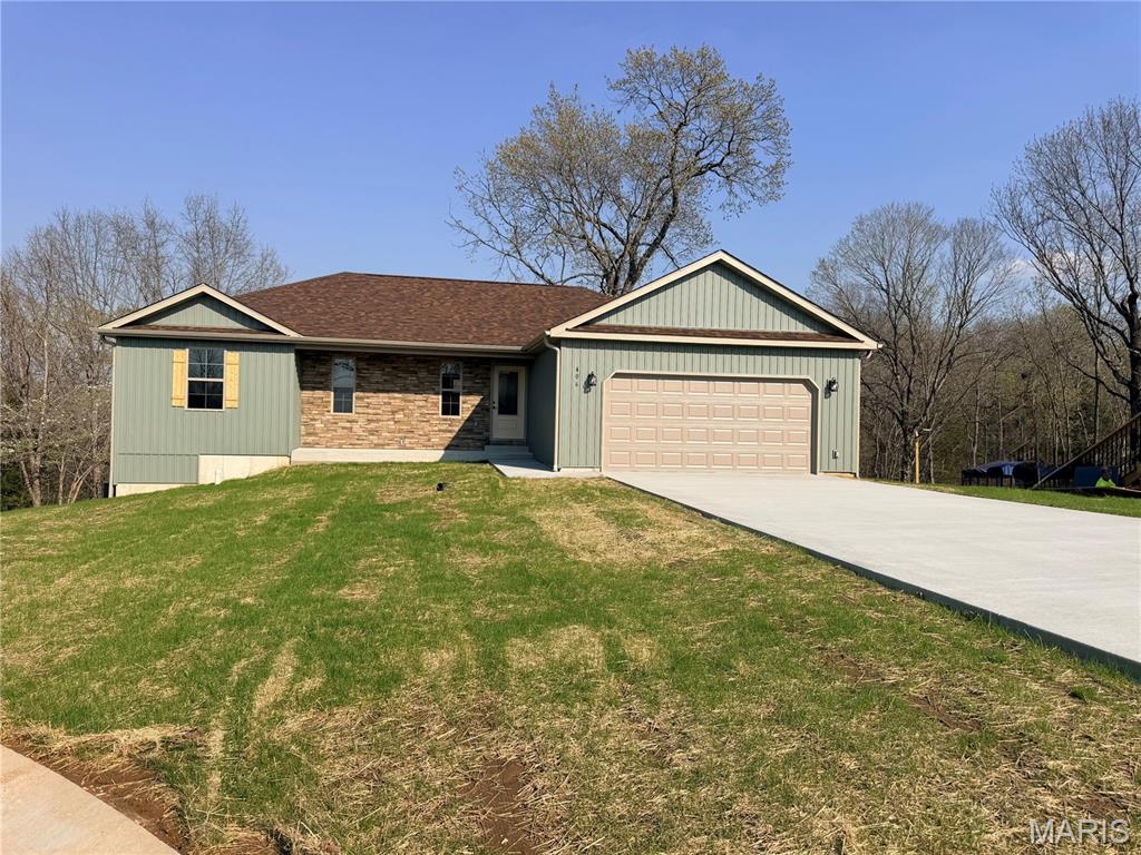 Welcome home to this Ozark model new construction home, with estimated completion of March 2026! Situated in the Summit Pass subdivision, just minutes from the West gate of Fort Leonard Wood, this home features an open concept living space, with luxury vinyl plank flooring throughout. In the kitchen, find Black Pearl granite counter tops, stainless steel appliances, along with custom green cabinetry, including hickory center island, gold finishes & soft close drawers. Living area provides access to the covered deck, where you can enjoy the wooded view behind the home. The primary suite includes tile shower & glass door, as well as spacious walk-in closet. Main floor laundry is conveniently located off the garage. One additional bedroom & full bathroom round out the main floor. Downstairs, find a family room with access to the backyard, two bedrooms & bathroom, along with a large storage room. All bathrooms include white vanities.  Main floor common bath and lower level bath both include tub/shower combo. Home includes spray foam insulation, Carrier heat pump HVAC system, solid surface flooring, Owens Corning shingles & insulated garage doors. One year Builder's Warranty included.