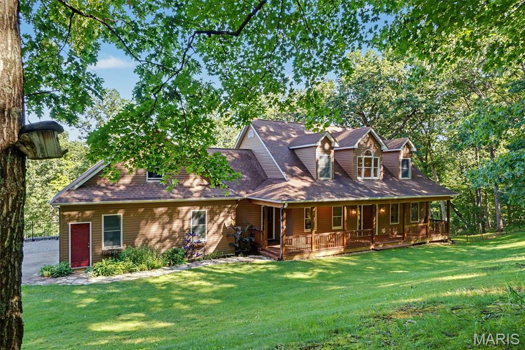 Something different and exciting just hit the market! Immediately available home with fantastic out building and 12 acres, in the Washington School District.  Located halfway between Lake St. Louis and Washington, take a drive to the country, to enjoy some of the most beautiful hills and fields of Augusta Missouri!  The Katie Trail, Klondike Park, and Matson Park are all just minutes away! Have you been dreaming of that "log house" appeal without the maintenance?  The insulated vinyl siding on this one and a half story home is a custom color to mimic cedar. With its welcoming full covered front porch as well as a dynamic cedar deck and additional screened porch out back, you will love to sit outside and listen to the morning songbirds. Total seclusion!  Vaulted great room, with sky lights, wall of windows and an upper balcony, offer comfort with the wood floors and the wood burning fireplace.  Main floor includes a formal dining room with glass French doors. Wood cabinets, stainless appliances, and a display shelf high above your head, show off in the efficient kitchen - opening out to the screened in deck for those private evening dinners.  Main floor primary bedroom is large, with sunny bay window overlooking the deck, with his and her closets, and bath with separate shower and jet tub. The upper two bedrooms both feature a cute dormer window and very large walk-in closets for the kiddos.  LL can be finished with that same wall of windows and walk out.  Currently there is a finished office room and full bath in the LL.  Uniquely, the 33' x 27' lower garage offers tons more storage if needed.  But wait, the 30' x 40' outbuilding is a showstopper of a workshop! Fully finished, concrete floors w/drain, 220 electric, heat, and a power lift that stays.  Your very own private oasis!