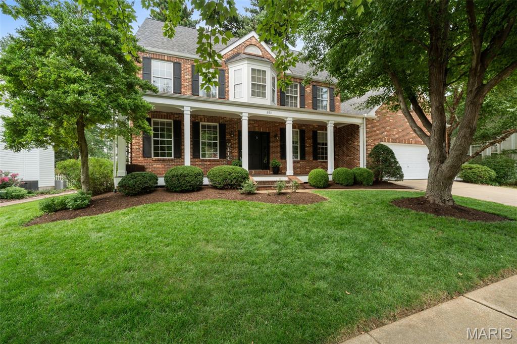 Welcome to this Flower Homes 2.5-story home, where a distinctive floor plan, classic architecture, and inviting living spaces come together in the charming Dickens Farm neighborhood. Its signature covered brick front porch offers the perfect place to enjoy your morning coffee and take in the peaceful, storybook charm that makes Dickens Farm so special. Inside, the welcoming foyer is flanked by a den and dining room, both accented by gorgeous tiger wood floors. Thoughtfully designed with the staircase tucked toward the rear of the home, the floor plan creates an uninterrupted flow to the spacious great room and beautifully updated white kitchen—the true heart of the home. Featuring a center island, stainless steel appliances, and generous workspace, the beautifully updated white kitchen has been the backdrop for making countless memories—from everyday moments to special occasions alike, with homemade meals shared, friends and family gathered, and sourdough baking in the oven. Just beyond, step onto the beautifully landscaped patio overlooking the level backyard, where magnificent mature trees create a peaceful setting for relaxing evenings, outdoor entertaining, or simply enjoying the stars overhead. Nearby, the convenient main-floor laundry room, complete with the washer and dryer included in the sale, adds ease to everyday living. The second floor offers four comfortable bedrooms, including a spacious primary suite with a walk-in closet and beautifully renovated luxury bath featuring a soaking tub, walk-in shower, dual vanity, and thoughtful storage. Three additional bedrooms share the hall bath. The home's distinctive floor plan continues on the third floor, where the fifth bedroom loft with an attached full bath offers exceptionally versatile living area.  Whether envisioned as a cozy retreat, guest suite, home office, media room, or spacious fifth bedroom, this unique space is ready to adapt to your lifestyle. The unfinished lower level offers abundant storage today and endless opportunities to create additional living space tailored to your needs. Enjoy the peaceful charm of Dickens Farm while being just minutes from major highways, shopping, dining, Ballwin Pointe and Rockwood Schools.