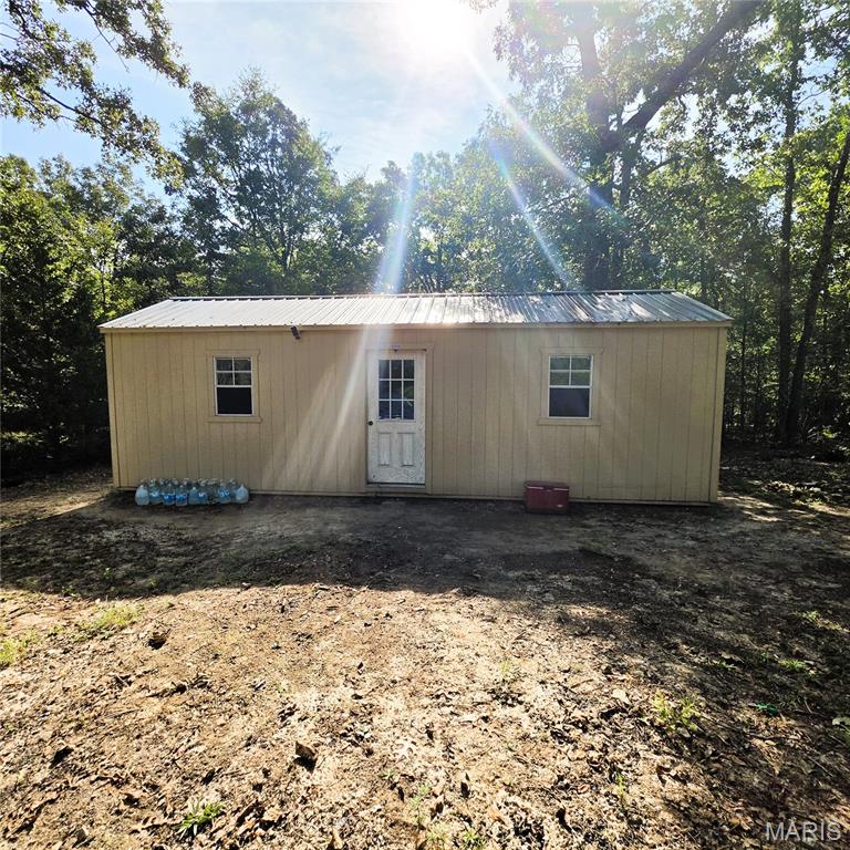 Located approximately 2 miles from Wappapello Lake, this 1.4-acre wooded property offers a quiet, remote setting with excellent access to outdoor recreation. The one-room cabin is unfinished and ready for customization, featuring a basic off-grid setup including a solar panel, car battery, and wood barrel stove. Surrounded by mature timber and set off a low-traffic county road, the property provides privacy and a simple retreat close to fishing, boating, and lake activities. Ideal for a weekend getaway, hunting cabin, or building site.