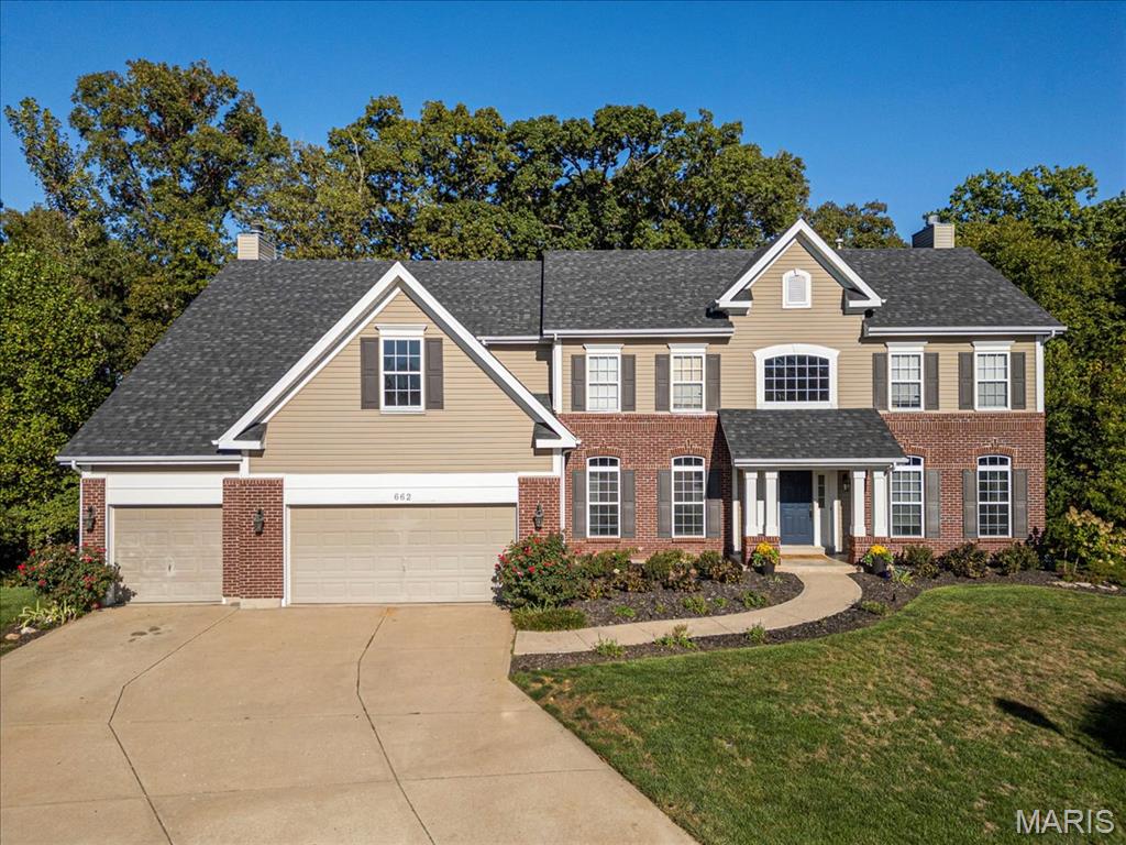 Welcome Home to the highly sought after subdivision of The Villages at Bainbridge in beautiful Dardenne Prairie! Nestled on a peaceful cul-de-sac, this stunning two-story residence offers elegance, privacy, and comfort in one perfect package. Step inside to find hand-scraped hardwood floors flowing through most of the main level, creating a warm and inviting atmosphere. The chef’s dream kitchen features custom cabinetry, center island breakfast bar, abundant countertops, stainless steel appliances, adjacent breakfast room and a cozy hearth room with a wood burning fireplace.  Step right out onto the composite deck overlooking the beautiful, private, heavily wooded backyard—a perfect retreat for morning coffee or evening entertaining. The main level also includes a spacious great room with a bay window and wood burning fireplace, a formal dining room ideal for gatherings, a private study/home office, and a convenient half bath. Upstairs, you’ll find four generous bedrooms and three full baths, including a luxurious primary suite with a walk-in closet and an updated spa-like bath featuring dual vanities, a soaking tub, and a separate shower. A bright loft area provides extra living space—perfect for a playroom, homework zone, or cozy reading nook. The finished walkout lower level is designed for entertaining with a wet bar/kitchenette, recreation room, bedroom, and full bath—ideal for guests or multi-generational living. Step outside to the covered paver patio and enjoy serene views and the quiet sounds of nature. This home perfectly balances luxury and livability—truly a rare find. This home also features many costly updates including 1 newer HVAC unit, 2 newer hot water heaters, a newer roof and front/side irrigation system. Close to all major conveniences including schools, shopping, entertainment and 3 major highways--all this plus subdivision pool, ponds and walking paths.