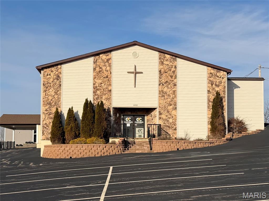 Large church building in excellent location on a very busy street. Approximately 1.44 acres m/l with 7680 sq ft bldg and large parking lot. Building features sanctuary with vaulted ceiling and stage, multiple offices, classrooms, kitchen area, banquet area and multiple bathrooms. Side entry has covered drop off area.  Building is in great condition and would lend itself to many other uses.
