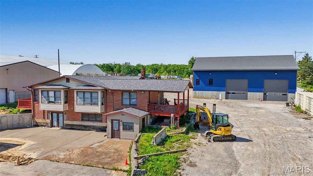 Interstate 70 Visibility ! Incredible Commercial Partial with Office, 2 Apartments,garage and 3300 SQ ft Outbuilding on over 2 acres of I-70 Frontage!  The brick building/office has over 4,000 +/- sq. ft. with 2 kitchens, 2 full baths, 3 laundry rooms, sunroom, ½ bath and numerous other rooms. This would be ideal for 2 Apartments on the upper level, while running your business out of the main floor office. Instant Income. Your recently updated and expanded Shoppe/Outbuilding is nearly 3000 sq ft and has  3 phase Electric, 8ft walls, 22ft+ Height Ceilings, and 2 Drive in Doors. The 2 acre site offers plenty of outside storage space for equipment,machinery, and implements as well. This is an excellent Opportunity for an owner user or an owner that needs storage, office, and 24 hour staff/employees on site. Directly on the Opposite of Hwy 70 as the New Multi Million TR HUGHES McBride  Development Elkhorn Ridge. Parcel is also just miles from the new American Foods Multi Billion Dollar Meat Processing Facility.