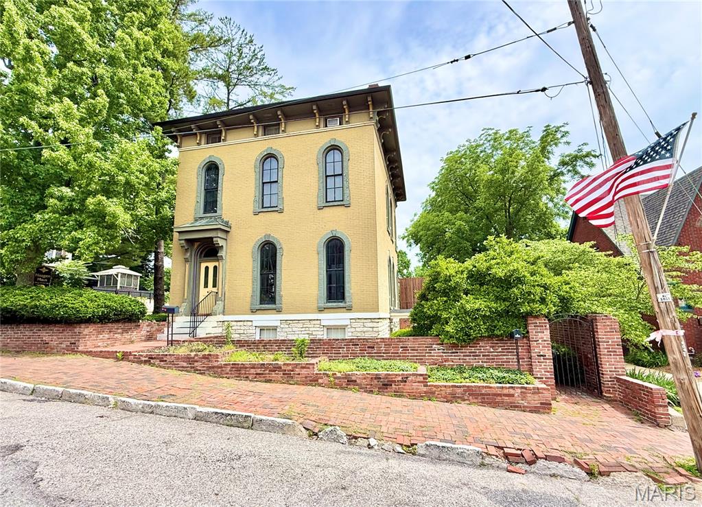 Commonly known as the Haagen Haus, this remarkable Civil War-era residence blends timeless elegance, rich history, and exceptional investment potential in the heart of Alton's charming Christian Hill neighborhood. Showcasing over 4,300 square feet of beautifully appointed living space, this fully furnished property features stunning hardwood floors, soaring ceilings, four fireplaces, attractive finishes and fixtures, and views of the iconic Alton Bridge.

Currently operating as a successful hospitality-oriented guest house, the property is configured as four separate living units, each with its own kitchen and included appliances, offering incredible flexibility for investors, owner-occupants, or multi-generational living. Generate income by renting all four units, or enjoy the home as your primary residence while leasing one, two, or three additional units to offset ownership costs.

The lower-level suite offers a private entrance through a wrought-iron gated courtyard, full lookout windows, a private brick patio, and the perfect setup for an in-law suite, guest quarters, or additional income-producing space.

Situated on a prominent corner lot exceeding 9,000 square feet, the outdoor spaces are equally impressive. A private brick-sided courtyard patio with included gazebo provides an inviting setting for entertaining, special events, family gatherings, or peaceful relaxation. Charming brick-lined streets and the character-filled surroundings of Christian Hill further enhance the property's appeal.

With an established Airbnb presence, excellent guest reviews, proven rental history, growing tourism demand, low-maintenance management, and furnishings included, this turnkey opportunity is ready for immediate enjoyment and income generation. Whether you're seeking a distinguished historic residence, a thriving hospitality business, or a unique live-and-earn opportunity, the possibilities are truly endless at the Haagen Haus.
