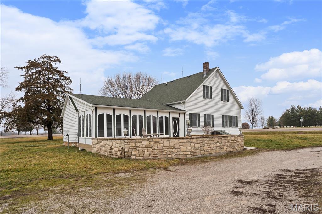Sitting on over 2.5 acres in the highly sought-after Waterloo School District — this farmhouse offers space, charm, and flexibility in a peaceful country setting. Inside you’ll find beautiful wood floors, high ceilings, and oversized windows that fill the home with natural light. The spacious kitchen features a center island perfect for gathering, meal prep, or morning coffee with a view. A separate dining room provides space for family meals and entertaining, while the porch offers the perfect spot to relax and take in the beautiful scenery. Main floor laundry adds everyday convenience. The home includes 3 bedrooms and 2 full baths, plus a large office on the main level that could easily become a primary bedroom by adding a closet — ideal for those seeking main floor living. Outside, enjoy over 2.5 acres of open space with multiple outbuildings offering endless possibilities for storage, hobbies, livestock, workshop space, or small business use. Country feel. Great location. Acreage. Outbuildings. Flexibility. This is the farmhouse lifestyle — without giving up convenience. The home and big outbuilding are in need of new roofs, seller has priced to sell as-it is.