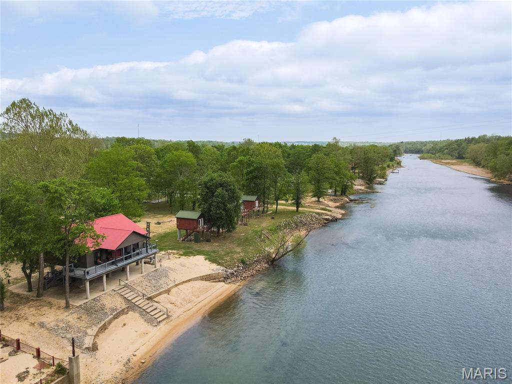Opportunities like this on the Current River don’t come around often. With 160 feet of river frontage and private access to a rare stretch of beachfront, this property puts you right on the water—no compromises.

The 3-bedroom, 2-bath cabin offers approximately 1,440 sq ft of well-designed space that feels both comfortable and functional. The main living area is open and airy, with vaulted ceilings and natural light that brings the outdoors in. The kitchen is clean and modern, featuring granite countertops, stainless appliances, and plenty of room to gather, cook, and entertain.

Step outside and it’s all about the setting. A spacious deck overlooks the river, while the private beachfront gives you direct access for swimming, floating, or launching a kayak. Whether you're looking for a personal escape, a second home, or a property that generates income, this one checks every box—with a strong history as a short-term rental already in place.