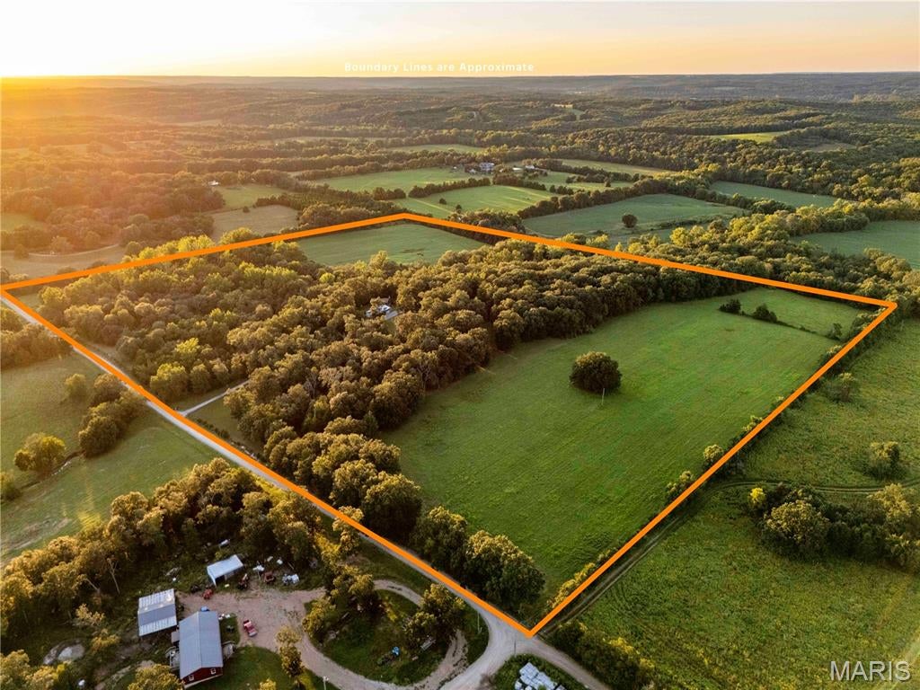 Here's your chance to get that perfect hobby or hunting farm, or set up your dream place. 50 acres just south of Owensville with a strong mix of tillable ground, timber, a live creek, and a tidy, well-kept home and two additional shops make this place a fantastic value. The 50 acres includes approximately 23 acres of pasture/tillable ground and 27 acres of mature timber, with Big River Creek winding through the property and a rock bluff overlooking the creek. The 2-bedroom, 3-bathroom home is in great shape and very clean. The owners have taken care to keep the house in good condition for years. The main floor has two bedrooms, one of which is a suite with a private full bath. There is an additional full bathroom. The kitchen has a large pantry that can convert to a main-floor laundry room. The main living space is a large open concept that flows from kitchen to dining room to living room, anchored by a nice stone fireplace. Large casement windows and patio doors bring in natural light. Step out onto the large, elevated deck to take in the sights and sounds of the land. Head down to the partially finished walkout basement, where you'll find another full bathroom and a rec room with another fireplace. The basement has full-size patio doors and windows and could easily be finished the rest of the way. This space is currently used as a large living room and an additional sleeping area. You'll never go cold with the additional wood-burning furnace, but you'll also have central HVAC for when you don't want to split wood. The 50 x 30 shop has 200-amp service, a concrete floor, a 16 x 7 garage door, and a gable-end sliding door for taller equipment. An additional 20 x 30 newer shed has a garage door, electric, and a concrete floor. The land is the ideal mid-Missouri mix of tillable and pasture ground, timber, and a meandering creek. Take a stroll, and you'll realize you have a bit of everything; picnic along the creek and take a swim in the deep holes. Right now, the bottom ground is being farmed, and the upper field has been cut for hay. The timber sets central to the property and follows the creek. You'll notice large white oaks, hickories, and some walnuts. This 50-acre property is the ideal hunting or hobby farm, already set up with all the improvements. Or just a great place to live full-time, enjoying the quiet. Give us a call today before it's gone!