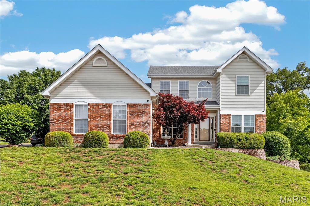 Nestled on a premium corner lot in the desirable Emerald Forest community, this beautifully maintained two-story home offers exceptional curb appeal and thoughtful landscaping. Step inside to a welcoming center hall floor plan featuring rich wood flooring and elegant formal living and dining rooms.  The open-concept kitchen and family room are truly the heart of the home, showcasing an expansive updated kitchen with stainless steel appliances, granite countertops, tile backsplash, breakfast bar, and built-in desk area. A convenient drop zone/locker space and main-floor laundry add everyday functionality. The inviting family room features custom built-in bookcases, a stunning five-bay window, and a cozy wood-burning fireplace. Upstairs, the spacious primary suite boasts vaulted ceilings and a luxurious en suite bath with double vanities, separate shower, and whirlpool tub. Three additional bedrooms and a full bath complete the upper level. The finished lower level offers incredible flexibility with a recreation room, play area, game room, half bath, and additional space ideal for an office, sleeping area, or home gym. Additional highlights include a three-car side-entry garage, newer water heater, new refrigerator and dishwasher, irrigation system, and newer aluminum fencing.  This move-in ready home combines space, style, and functionality—welcome home!