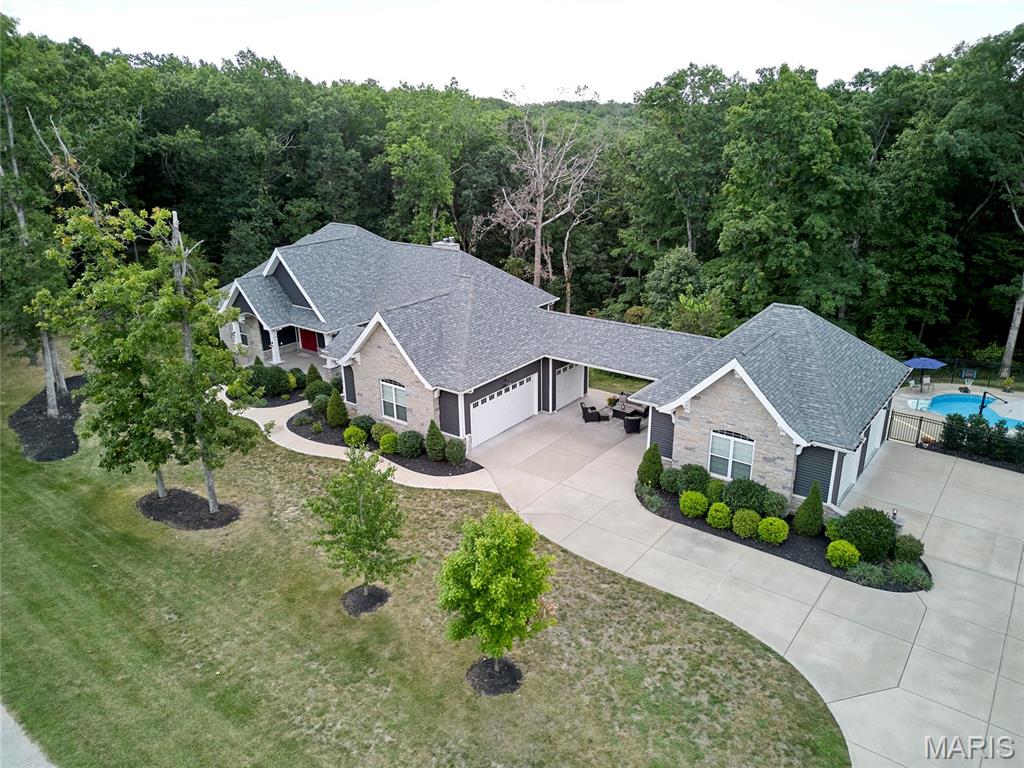 Looking for a home that you never need to vacation from.....then this is the one! This stunning custom ranch offers over 4,800 sqft of spacious finished living space with 10 foot ceilings on the main level and 9 foot in the lower level. Natural light abounds throughout the main living area offering scenic views, wood burning fireplace that flows into the chef's gourmet kitchen complete with range hood, backsplash, double ovens, Cambria quartz and large walk in pantry and dining space perfect for dinner parties. Primary suite offers a luxury ensuite bathroom & 3 generous guest bedrooms. Walk out LL is set up perfect for gatherings or movie nights with 9' ceilings, wet bar, wine cellar, wood fireplace, full bath & guest room. So many outdoor living spaces to enjoy from front porch, deck running the length of house, breezeway patio, raised bed fenced in garden and heated saltwater pool with its own full bathroom perfect for those epic summer pool parties! The 5 car over size garages are perfect for your outdoor toys and hobby or shop area. All of this located on a peaceful & private wooded cul de sac lot in the Defiance wine country, offering the Katy Trail, multiple parks biking & hiking trails, lakes and MO River Valley, Historic Daniel Boone Home site, Boone Valley Golf Club & close to Chesterfield Valley restaurants & shopping. With so many options to relax, recharge, entertain, or just enjoy nature you might just take less vacations from this wine country estate lifestyle!