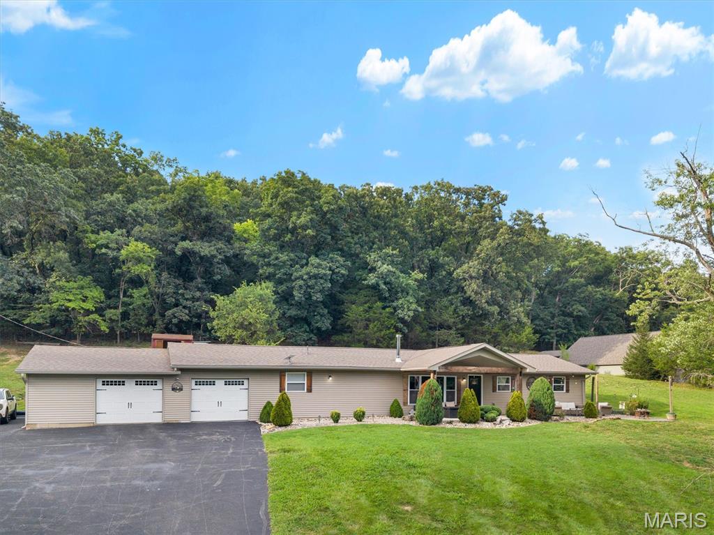 Welcome home to the place where modern farmhouse style meets peaceful country living. Nestled on 3.2 private acres, this beautifully remodeled 4-bedroom, 2-bath home offers 1,600+ square feet of thoughtfully designed living space where every detail has been carefully curated.

From the moment you step inside, you'll appreciate the warmth of rich hardwood flooring, stunning granite countertops, classic subway tile, shiplap accents, floating shelves, farmhouse-inspired finishes, reclaimed barnwood details, and custom crown molding that ties together the kitchen, dining, living area, and primary suite. The inviting wood-burning stove creates the perfect gathering place for cozy evenings.

The custom bathrooms feel like a boutique retreat, highlighted by a luxurious primary bath featuring heated floors—because warm toes on a winter morning are a luxury you'll quickly wonder how you ever lived without.

Outside is where this property truly comes alive. Relax beneath the covered front porch while overlooking the breathtaking hemlock tree and listening to the sounds of nature. The wooded surroundings provide an abundance of wildlife to observe throughout the seasons, creating a peaceful setting for outdoor enthusiasts. With plenty of room to explore, enjoy hiking, bonfires, gardening, or simply taking in the fresh air. The acreage also provides ample space for recreational vehicles, making weekend ATV rides and outdoor adventures part of everyday life.

Complete with an OVERSIZED two-car garage, exceptional privacy, and countless custom upgrades throughout, this is more than a home—it's a lifestyle where craftsmanship, comfort, and the beauty of the outdoors come together in perfect harmony. Welcome to the place you'll never want to leave.