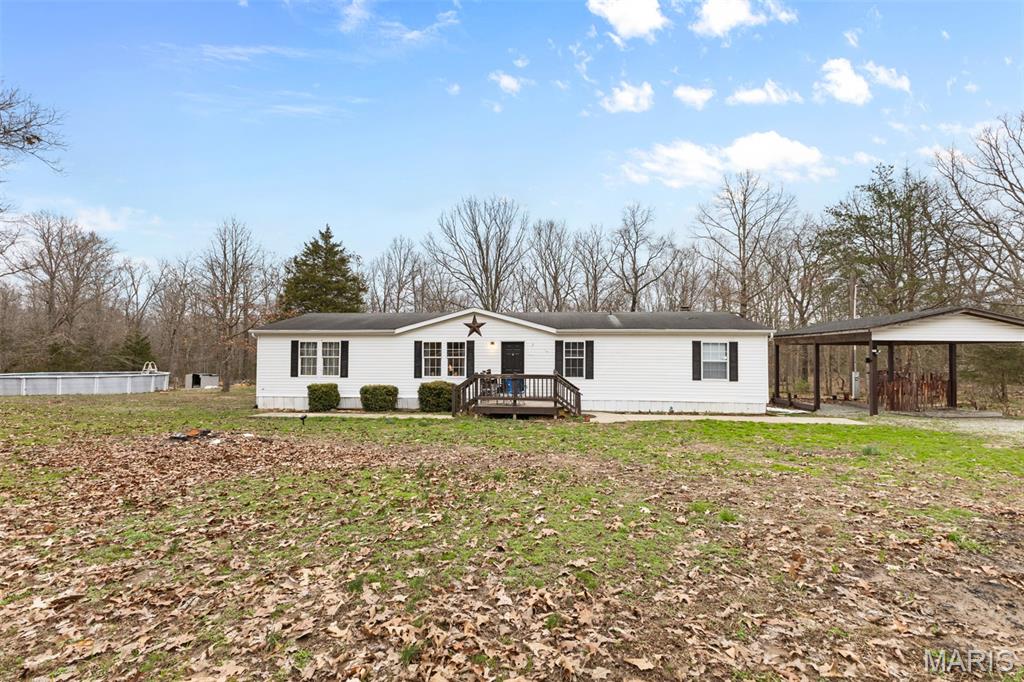 Here is your chance to live the country at an affordable price!! Nestled on a 3-acre lot sits this very well-maintained home. Over 1,800 square feet of comfortable living space. New flooring throughout, highlighted by a cozy fireplace. The kitchen boasts a pantry and island, ideal for cooking enthusiasts and entertaining. Main bedroom has a nice size closet with a second walk in closet in the master bathroom that has been beautifully redone. Step outside to the screened in porch or the large deck where you can overlook the above ground pool, perfect for summer fun or peaceful evenings. A two-car carport and circular drive offer easy access and plenty of parking for guests. Recently updated electrical system ensure safety and efficiency. Don't miss out on this opportunity to own this slice of paradise!
