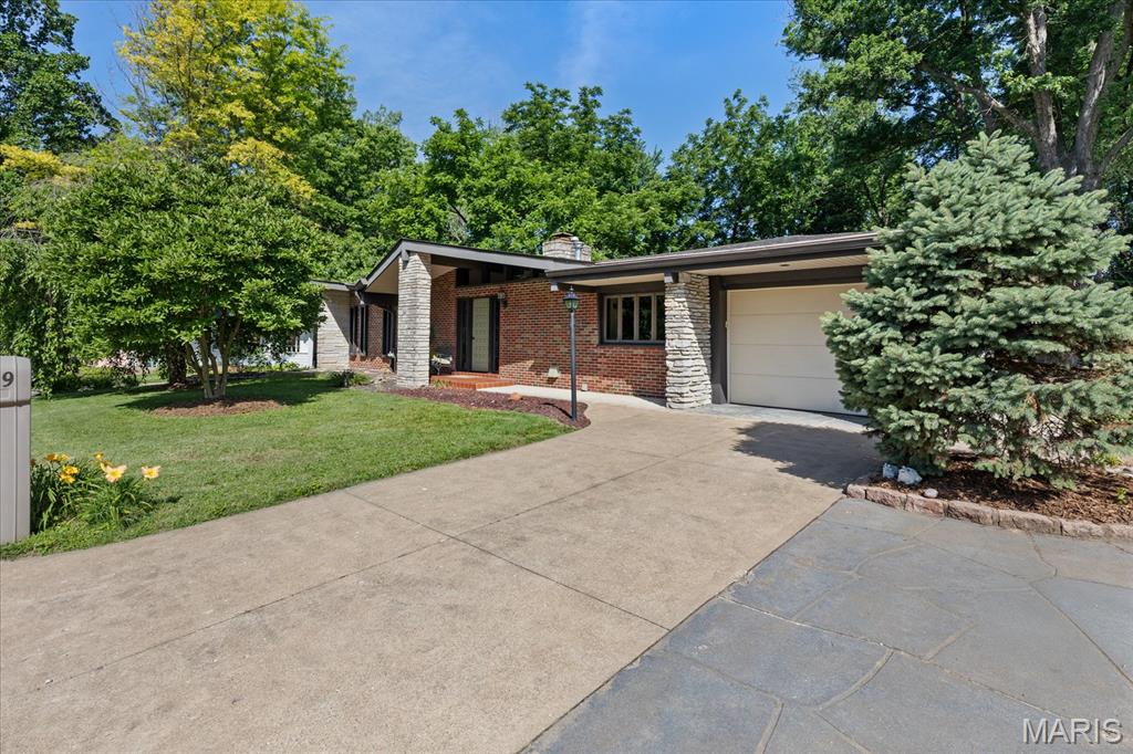 This one-of-a-kind, must-see home is a beautiful, move-in-ready 3-bedroom, 2-bath ranch located on the highly desirable Collage Drive. Custom stonework and woodworking are featured throughout the entire home.

As you enter, you’re welcomed into a stunning living room with vaulted wood plank ceilings, a striking stone accent wall, and a stone fireplace with custom built-ins on the opposite side. The main level also includes a cozy four-season room, perfect for relaxing with a good book or a cup of tea.

The kitchen features quartz countertops, abundant cabinetry for storage, and a convection oven. The knotty pine dining room is filled with natural light and provides access to one of the large seating areas in the backyard. The main level also offers three bedrooms and a beautifully remodeled bathroom.

The lower-level family room includes a large bay window for additional natural light and a convenient walkout. The home offers an impressive amount of additional and hidden storage throughout. And for hobbyists—there’s a woodworker’s dream shop area complete with loads of cabinets and countertops for all your projects.

The backyard is a private oasis, backing to trees and showcasing custom stone and brickwork throughout. Enjoy excellent seating areas and a large 27x18 brick patio that overlooks the entire backyard.

LOCATION, LOCATION, LOCATION - Conveniently located near local parks and schools, and just minutes from Historic Main Street.