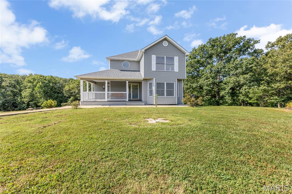 Welcome to a quiet country sanctuary tucked away on 26 breathtaking, tree-lined acres in scenic Sullivan, Missouri. This charming two-story home with a brand new roof offers roughly 1,820 square feet of finished living space designed to capture the surrounding natural beauty. You are welcomed by a large front porch equipped with its own swing, making it the perfect spot for a morning cup of coffee or an evening beverage. Step through the front door into an inviting foyer that flows seamlessly into the home's primary living spaces. The expansive living room serves as the heart of the main floor — a light-filled gathering spot framed by large windows with views of the surrounding land. Right off the living room sits the dedicated dining area. The functional kitchen offers abundant cabinetry and leads naturally into a bright breakfast room where you can easily stay connected to the conversation. A convenient main-level full bathroom and dedicated laundry room complete the main level for effortless day-to-day living. Head upstairs to find a sprawling primary suite that easily accommodates a full king set with room to spare, featuring its own hallway leading to the primary bathroom. The cozy second bedroom provides a quiet retreat for family, guests, or a home office, located right next to another full upper-level bathroom. Downstairs, the full walk-out basement expands your living space even further. A massive recreation room stands ready for game nights, a home gym, or a media lounge, while a huge utility room offers endless storage or space for a workshop. A fourth full bathroom completes the lower level. Outside, step off the porch or the large composite deck to explore private trails, store your gear in the detached garage, or simply enjoy the ultimate freedom of 26 private acres. Schedule your private tour today!