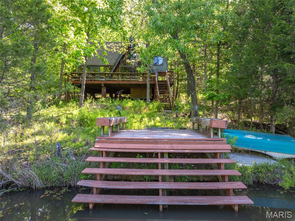 Here’s your chance to get into Innsbrook Resort at a price point that leaves room to make it your own. This 2 bedroom, 1 bath chalet could use some updating and TLC, but the setting and potential are hard to ignore.  Set on a nice level lot with a circle drive and easy access to the lake. The property offers a great outdoor setup for fishing, kayaking, and enjoying the outdoors. The lake view is there.  Just trim the trees and clear the brush to really open it up. Inside, the expanded living room features hardwood floors, some decorative tongue-and-groove walls, a wood-burning stove, and an entire wall of windows. The main-level bedroom is oversized with vaulted ceilings, a closet, and direct access to the expanded bathroom with a larger shower. Upstairs is the second bedroom plus loft for additional guests.  Properties with this kind of setting, usable lot, and lake access don’t come along at this price very often. With some vision and improvements over time, this chalet could really shine again. Conveniently located near the golf course and clubhouse. Property is being sold As Is, and seller will make no repairs. Buyer is responsible for determining the square footage of the building.