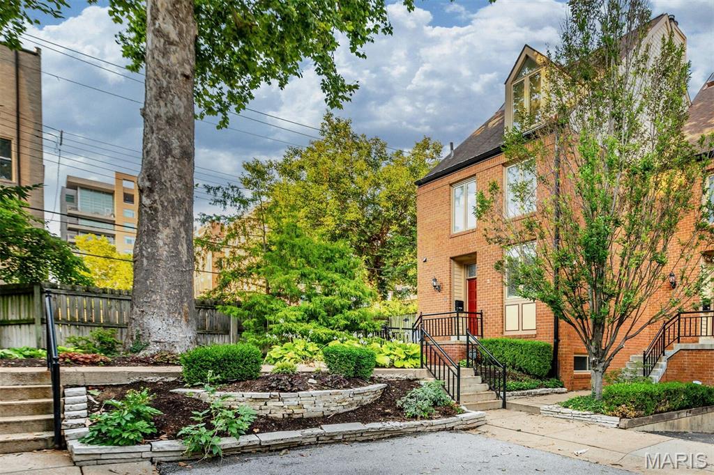 Experience sophisticated Central West End living in this exceptional four-level luxury townhome, ideally located just steps from premier dining, shopping, Whole Foods, BJC/Washington University Medical Center, and only two blocks from Forest Park. Thoughtfully updated throughout, this rare end-unit residence offers the space and functionality of a single-family home without the maintenance. The inviting open floor plan is filled with natural light and showcases rich hardwood floors, custom built-ins, a gas fireplace, and elegant entertaining spaces. The beautifully renovated kitchen features custom cabinetry, quartz countertops, stainless steel appliances, and seamless flow into the dining area. Double doors open to a spacious private patio, creating the perfect setting for indoor-outdoor living. The second level offers two generously sized bedroom suites, each with hardwood flooring, double closets, and beautifully updated en-suite baths. The third floor provides a spectacular vaulted bonus room with skylights, ideal as a family room, home office, fitness space, or additional bedroom. The finished lower level expands the living space even further with a guest suite, large walk-in closet, full bath with separate tub and shower, laundry area, and abundant storage. Additional highlights include updated windows, a fully fenced private outdoor retreat, tasteful neutral paint, and the highly coveted detached two-car garage. Combining luxury finishes, flexible living spaces, and an unbeatable walkable location in the heart of the Central West End, this move-in-ready residence is a rare opportunity to enjoy one of St. Louis' most sought-after urban lifestyles.
