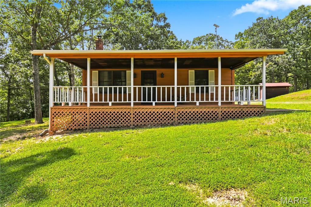 Looking for peaceful country living with room to grow? This charming 2 bedroom, 1 bath home sits on nearly 3 beautiful acres surrounded by mature trees and woods, offering privacy, versatility, and endless possibilities. Inside, you'll find 1,260 sq ft of living space with two generously sized bedrooms, a beautifully remodeled bathroom featuring recessed lighting, updated light fixtures with convenient night-light mode, and a wood-burning stove installed and professionally inspected in 2023. Step outside to the expansive 327 sq ft front porch, perfect for relaxing, entertaining, or enjoying the peaceful surroundings. Major updates include a full roof replacement with architectural shingles in 2024 as well as new kitchen appliances that same year and a new water heater in 2025. The oversized carport offers ample clearance for an RV, camper, or recreational vehicles and is equipped with electricity and abundant lighting. The property also includes five additional outbuildings, including a guest house with 3 multi use rooms and a little outdoor enclosure on the rear of building, a former horse stall thoughtfully transformed into a one of a kind entertainment space featuring a custom-built stage crafted from reclaimed wood salvaged from the original structure, along with electricity and lighting creating a truly unique setting for gatherings, live music, hobbies, or creative projects. Two large storage sheds and an additional small shed provide plenty of room for tools, equipment, and extra storage. Whether you're looking for a full-time residence, hobby property, weekend retreat, or space to create your own vision, this one of a kind country property is full of charm, flexibility, and opportunity.