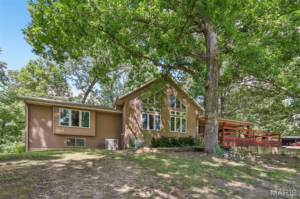 POND-SIDE PARADISE!  This peaceful 12.88 acre retreat is located just seconds from town and features a private pond, woods, a gazebo with swing, and a lovely 3 to 4 bedroom home with gorgeous bamboo flooring throughout the main level.  There is a fireplace in the great room, a wood burning stove in the large living room, stainless steel kitchen appliances included, a detached 2 car garage with a carport, a loft that can be used as the 4th bedroom, and a walkout lower level.  There's also another outdoor storage building, back patio, plenty of basement storage, and a wonderful deck that you can enjoy as you gaze out over the water.  Finding a parcel with this much land close to city amenities is rare, so call soon to tour and make it yours!