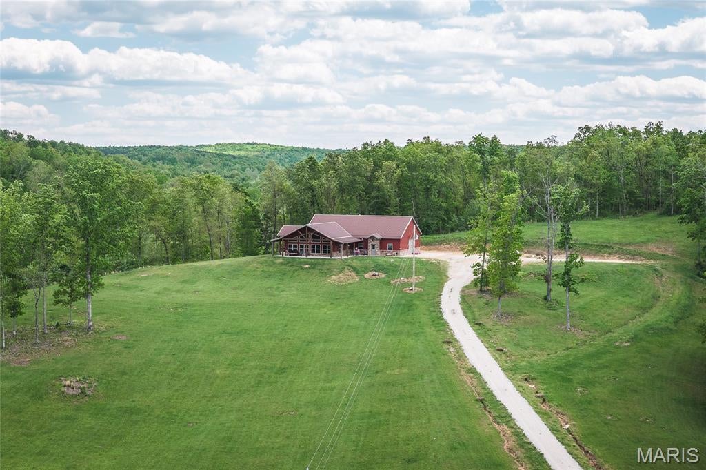 Escape to the Ozarks with this exceptional 56-acre property in Crawford County, Missouri, offering privacy, beautiful wooded terrain, abundant wildlife, and a custom home overlooking the countryside. Perched atop a hill, the 2,200 sq ft home features 2 bedrooms, 3 bathrooms, and a non-conforming room/office, providing comfortable space for family, guests, or a weekend retreat. An attached garage includes a convenient storage loft for tools, equipment, and seasonal items. Inside, the home showcases impressive craftsmanship, including completely custom kitchen cabinetry, custom wood flooring, and detailed woodwork throughout, creating a warm and distinctive feel. Recent exterior improvements include new gutters with gutter guards, and the home was freshly stained in December 2025. A Generac backup power system provides added peace of mind. The property is predominantly wooded, with beautiful mature hardwood timber providing privacy, shade, and excellent wildlife habitat. Scattered open areas and pasture complement the timber and offer ideal locations for food plots, gardening, or other recreational uses. Crooked Creek winds through the middle of the property, providing year-round water and enhancing the property's natural beauty. The abundant hardwoods and water source create an excellent habitat for deer and turkey, making this a fantastic hunting and recreational property. Located just 15 minutes from Steelville, 5 minutes from Crooked Creek Conservation Area, and only minutes from the Meramec River, this property puts some of the area's best floating, fishing, hunting, and outdoor recreation within easy reach. Whether you're looking for a private homestead, hunting retreat, or Ozarks getaway, this 56-acre property offers a rare combination of custom living and natural beauty. Call today to schedule your private showing.