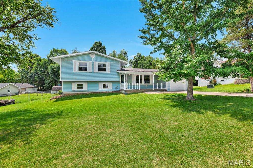 Welcome home to this spacious split-level home in the heart of Union, Missouri! Conveniently located just minutes from local schools and the center of town, this property offers the perfect combination of comfort, space, and outdoor living. The inviting covered front porch welcomes you inside, where the main level features a comfortable family room, dining area, kitchen, and convenient laundry area. Just a few steps upstairs, you'll find three bedrooms and a full bathroom, providing a functional layout for everyday living. Head a few steps down from the main level to discover an expansive recreation room, the fourth bedroom, and a second full bathroom. The bedroom also features its own exterior entrance leading directly to the backyard's concrete patio— and this space could also be used for a home office, guest space, hobby room, or workout area. Outside, you'll love the large yard with established garden areas ready for your favorite flowers or vegetables. The beautiful yard is accented by a variety of mature trees that provide shade, beauty, and character throughout the seasons. Relax or entertain on the oversized deck, recently stained and complete with a retractable awning, allowing you to enjoy the outdoors in comfort no matter the weather. With multiple living spaces, a flexible floor plan, and plenty of room to spread out both inside and out, this home is ready for you to make it your own.