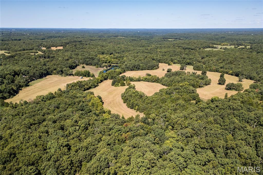 Lazy H Ranch is a rare opportunity to own 132 private acres in Crawford County, Missouri, just three miles south of Steelville, MO. This exceptional recreational property, hunting property, and private country retreat offers the perfect mix of mature timber, open pasture, established trails, and abundant wildlife, including excellent deer hunting and outdoor recreation.

Water is a major highlight, featuring a stocked 2.5-acre lake with dock, ideal for fishing, swimming, kayaking, or launching a small boat. Two additional ponds and seasonal creeks add natural beauty, wildlife habitat, and everyday function to the land.

A private drive leads into the property, creating true seclusion and privacy while still offering convenient access to Steelville, local services, and nearby outdoor destinations. The home is a 3-bedroom, 2-bath, 1.5-story barndominium with an open-concept floor plan designed for comfortable country living. An oversized garage provides excellent space for equipment, recreational vehicles, ATVs, UTVs, boats, tools, storage, or workshop use.

The deep front porch runs the length of the home and offers peaceful views of the surrounding land — the kind of porch built for coffee, sunsets, wildlife watching, and quiet Missouri mornings.

Located close to town while feeling worlds away, Lazy H Ranch offers a rare combination of Missouri acreage, private land, water features, hunting, pasture, timber, trails, and residential improvements. Properties with this much usable acreage, water, privacy, and improvements this close to Steelville are increasingly hard to find.

Shown by appointment only. Duplicate Listing #26004423.12-0-00-007.010;15-3.0-07-0-00-003.000