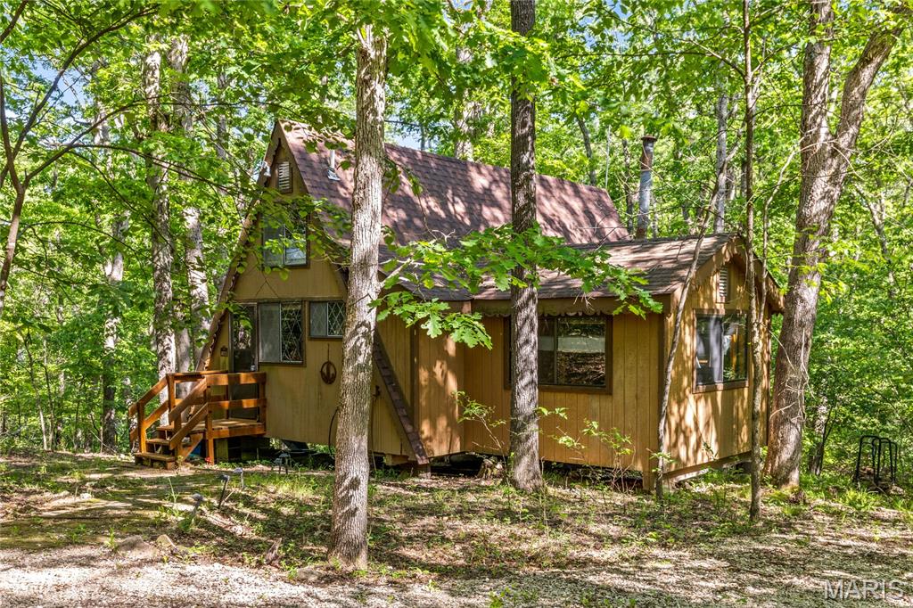 Nestled among the trees in Innsbrook, this charming chalet offers a peaceful retreat just a short walk from the beach areas at Lake Wanderfern. The open great room features soaring ceilings and floor-to-ceiling windows that bring in natural light and showcase the heavily wooded, level lot, creating a cozy atmosphere perfect for relaxing weekends. The main-level bedroom is currently configured as a bunk room, while the upper loft features both a queen bed and futon, bringing the chalet’s sleeping total to eight. Outside, enjoy evenings around the firepit or take a quick walk to nearby Seabrook Beach and Wanderfern Lake. Sold completely furnished and turnkey, this inviting getaway includes all furniture, a golf cart, and water gear including paddleboards and tubes — everything you need to start enjoying the Innsbrook lifestyle immediately. Whether you're looking for a weekend escape or an affordable way to get into Innsbrook, this chalet is a perfect place to relax and enjoy all the community has to offer.