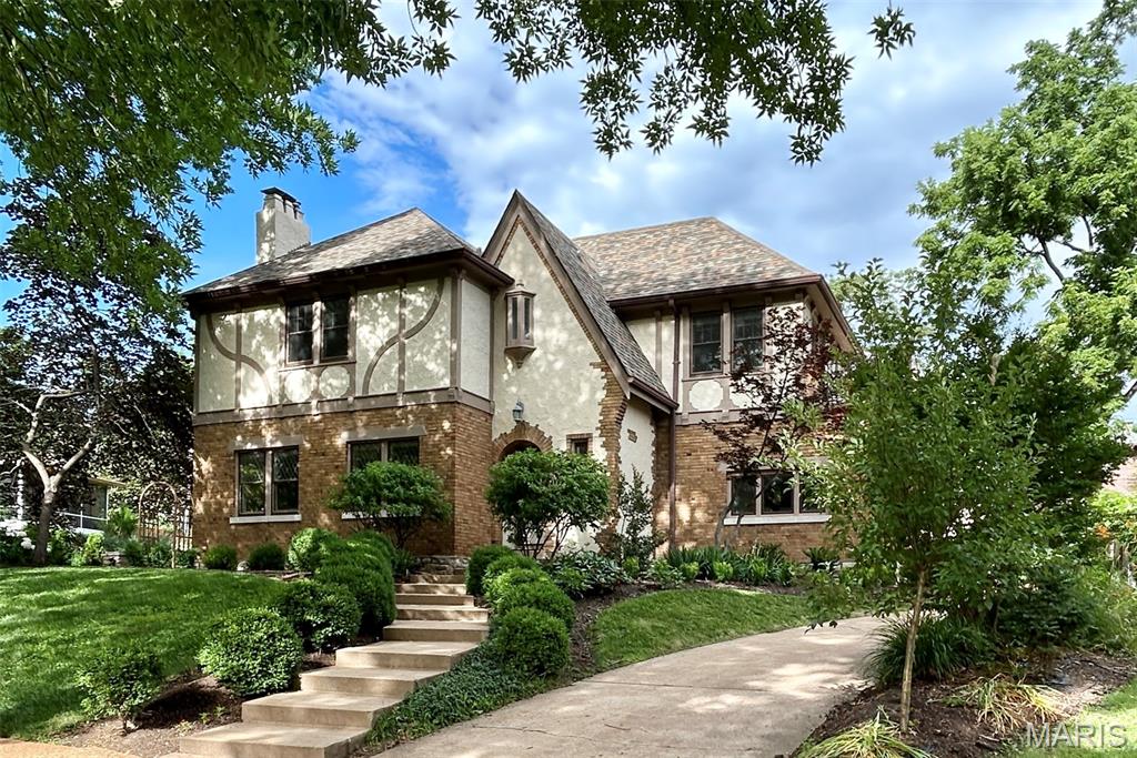 Perched on a knoll off Wydown, this storybook home has been thoughtfully opened and expanded for modern living. The expansive kitchen island anchors the open-concept family room, where multiple windowed doors open to the gardens, creating the heart of the home and flowing seamlessly from the reception gallery. The dining room opens from the island area and connects to the front living room, centered around the fireplace with intricate mantel. The sunlit recreation room is also accessible from the reception area. Upstairs, the primary suite offers a corner exposure and an updated bath with a double vanity. Three additional bedrooms, an updated hall bath, and a delightful side terrace overlooking the neighborhood complete the second floor. A partially finished attic with rear windows offers additional space to explore. The lower level includes a private office, laundry area, and a versatile multipurpose room. Outside, a stone patio is surrounded by landscaped gardens, while an oversized two-car garage, built in 1995, provides added convenience. Many recent updates include new windows with screens in all bedrooms (2024), a new roof (2023), and electrical updates (2023). Located within the Clayton School District. Showings begin Friday, June 19th. Furnishings may be included with the house.
