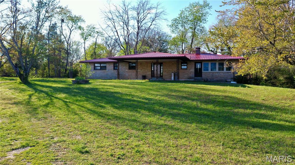 Check out this charming home on 1.18 acres located just outside the city of Salem. Sandstone siding gives this 1973 ranch style home plenty of curb appeal.  With 1,650 sq. ft. on the main level offering the living room with lots of windows, dining area and kitchen with plenty of wood cabinets and a peninsula for additional eating space. Off of the dining area is a 28' x 19' glassed-in sunroom with wood burning fireplace (buyers should have inspected prior to use). There are 3 bedrooms and 2 baths on the main floor as well with the primary bedroom having a walk-in closet and 3/4 bath. The full, partially finished walk-out basement offers a family room with wood fireplace (buyers should have inspected prior to using), pool table included and sliding doors out to patio/carport. Also located in the basement is a laundry closet, 3/4 bath, an additional room that could be used for crafting or an office, a storage room and a furnace room. Electric heat, Victor Wood Furnace and central air. 2 outbuildings. City electric and drilled well. This property offers lots of potential and conveniently located to town in a subdivision. Property is selling AS-IS.