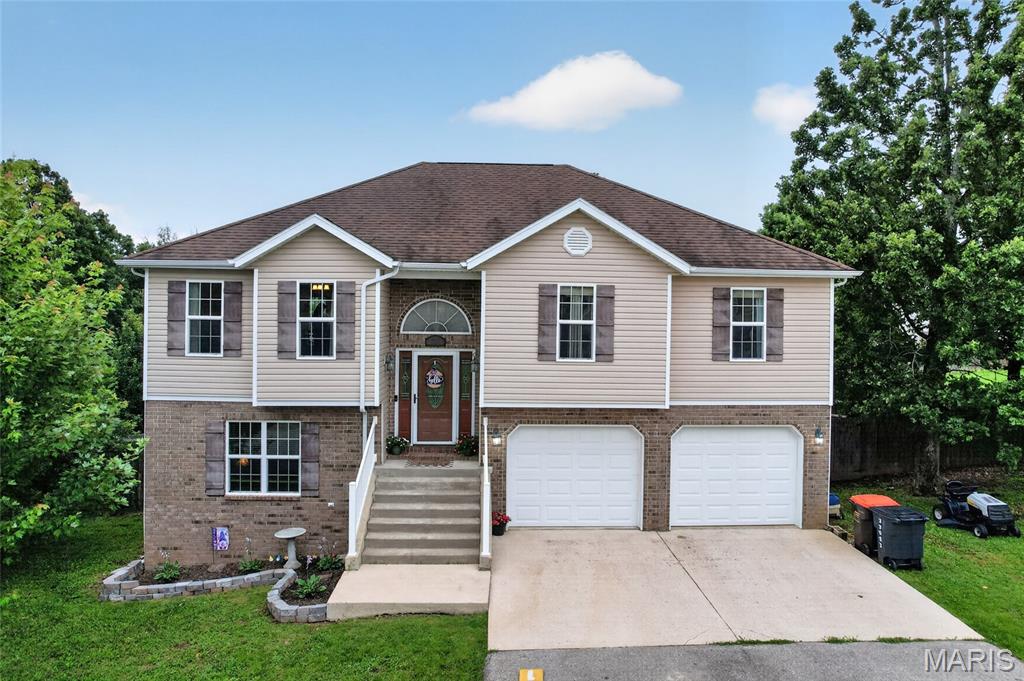 Welcome home to 23022 Ransom Rd in the Taylor Hills Subdivision! Enter through the front door to find a spacious family room, smartly adjoining an eat-in kitchen, along with wood cabinetry, new appliances and ample counter space. The dining space provides access to the deck, overlooking an impressive fenced yard. Down the hall, the primary bedroom includes a walk-in closet, en suite bathroom with jetted tub, separate shower and dual bowl vanity. Two additional bedrooms and one bathroom round out the upper floor. Head downstairs to a laundry room, conveniently located next to the garage entry, along with family room, bathroom and fourth bedroom.  Garage includes parking for two vehicles, hobby space and a separate utility room. Lower level family room includes access to the backyard, where there is plenty of room to run, play, garden and entertain! This home includes a new HVAC system and reverse osmosis water filtration system.  Located just a short drive from I-44, Fort Leonard Wood and downtown Waynesville, this offers the convenient location you desire, with the perks of a subdivision, without sacrificing space and privacy!