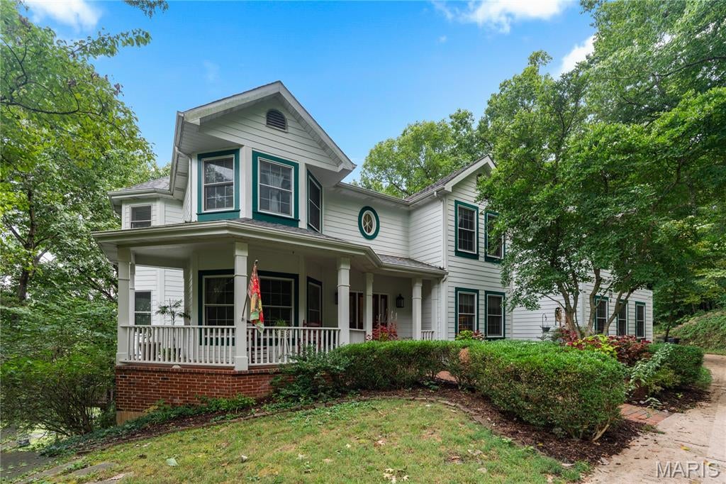 Nestled away and surrounded by 3.5 acres of natural beauty is this custom-built 7 bedroom, 4.5 bath, 2-story home in the highly sought-after Ossenfort subdivision in the Rockwood School District. Upon entering the home, you immediately sense the spaciousness of a grand open floor plan, with a 2-story great room, floor-to-ceiling windows providing breathtaking views, and a 2-story brick wood-burning fireplace. It opens up into a generous-sized screened-in porch overlooking a small pond with a water feature providing a serene retreat right in your own home.  The recently renovated, luxury eat-in kitchen, with custom cabinets, a large island, quartz countertops throughout, a lovely stand-alone coffee/beverage station, double built-in wall ovens, and a walk-in pantry, opens onto a private upper deck where you can drink your morning coffee and watch the sun rise. The main level also boasts the convenience of a home office and main-level laundry, as well as a bedroom area and ensuite bath, living room, and formal dining room. There are 6 bedrooms on the upper level which includes an expansive master suite and another bedroom with a smaller room attached to it perfect for a nursery, play room, exercise area, etc. Another flex space (library) and full bath complete the upper level. The expansive lower lever offers the option of an in-law suite or a space for multi-generational living.  This huge gathering space includes a family room and fireplace and a Buck Stove insert, a office with walk-in closet, game room/bonus room, full bath, updated kitchenette, workshop, tons of storage area, and 9' ceilings. Big entertainment or dining gatherings are no problem as the lower level opens onto a sweeping lower deck overlooking the back yard and 1.5 acre fenced pasture. If desired, the HOA permits 2 horses on the property. This amazing home is all electric and highly energy-efficient, has stunning millwork and arches, 3  HVAC zones, newer Hardyboard siding, a wrap-around covered front porch, 3 car garage, and beautiful landscaping. This impressive home with multiple bonus areas gives you the flexibility you need to customize your new home into your very own extraordinary private retreat. Welcome Home!