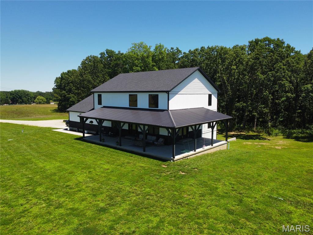 Welcome to an exceptional property where space, style, and functionality come together on 16 picturesque acres. Built just two years ago, this custom-designed home offers 7 bedrooms, 4 full bathrooms, 3 separate living areas, dual laundry rooms, an oversized side-entry garage, and additional concrete parking, creating the balance of everyday convenience and entertaining. The thoughtfully designed main level features an open-concept floor plan centered around a spacious kitchen complete with solid surface countertops, a tiled backsplash, pot filler, walk-in pantry, and a large center island with seating. The primary suite is privately situated at the rear of the home, offering peaceful wooded views, a luxurious bath, and a custom walk-in closet. Also located on the main level are a second bedroom, a dedicated office with a window and closet, an additional full bath, and a conveniently located laundry room just off the garage with custom mudroom storage. An impressive cable-railed staircase leads to the upper level, where expansive windows overlook the main living area below and fill the home with natural light. This level features an open family room, three generously sized bedrooms, a full bathroom, and a second laundry area, providing comfortable living space and added convenience for family and guests. The finished lower level was designed with fun and family in mind, featuring an oversized third living space with durable concrete floors, a large seventh bedroom, a full bathroom, central vacuum system, Culligan water system, and ample storage. Outside, the home makes a lasting impression with its bold architectural design, stone accents, vertical siding, and wraparound covered porch. As you travel down the long private drive, you'll pass a pond before arriving at this one-of-a-kind masterpiece. Conveniently located with easy access to Fort Leonard Wood and Interstate 44, this property delivers the perfect combination of rural living and everyday accessibility. This is country living at its finest. Rarely does a home combine acreage, modern construction, thoughtful design, tranquility of country living, and stunning curb appeal in such a remarkable package. This is country living at its finest.