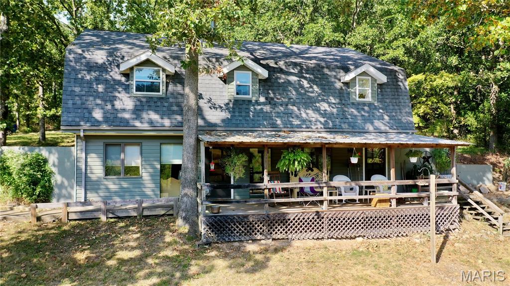 Travel down a private permitted Forest Service road to discover this beautiful, secluded 40-acre valley farm backing to thousands of acres of Mark Twain National Forest, offering endless opportunities for hunting, exploring and sightseeing! This unique raised ranch home features 4 bedrooms and 2 1/2 baths. The open kitchen offers abundant cabinetry, stainless gas range, microwave, and refrigerator. Cozy living spaces include a propane fireplace and soapstone wood stove, while a large pantry adds extra storage. Upstairs features a family room with propane ventless fireplace, 3 bedrooms including a primary suite with walk-in closet. Bathroom with clawfoot tub, and a sewing room/summer kitchen perfect for canning. Central A/C and forced-air propane heat were installed in 2016. Water Fork Creek flows through the property, providing year-round water and beautiful valley views from the covered back porch. The orchard includes 5 pear trees, 5 chestnut trees, 4 persimmon trees, 2 additional pear trees and a peach tree. Marketable timber adds even more value. Multiple outbuildings include a garage with concrete and electric; tractor shed with electric, horse barn with 2 stalls, feed and tack room, hay storage, water and lean-to for additional storage, plus a chicken coop with nesting boxes, garden shed with wood storage/potting area. Two wells provide water—one for the home and one for the barns. A whole-house generator with its own propane tank, plus an additional backup generator, complete this exceptional self-sufficient Ozarks retreat! Don't miss this one, schedule a private showing today!