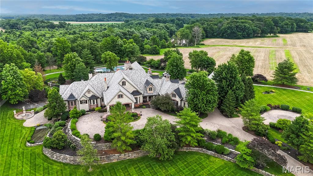 Once you come into browse the photos and study the details of this home, we think you will fall in love.  And, after you have taken it all in, we invite you to consider how much it might cost today to build new. Simply, you can begin by considering the exterior’s beautifully landscaped property with mature trees, paver stone driveway, natural stone retaining walls, exterior lighting, pond, patios, pool, porches & playground. Then, interiorly, take into consideration some of the elegant but practical features such as the polished natural stone & hand scraped wood floors, the entry foyer chandelier which is on a motorized chain to allow for easy cleaning, the Butler’s Pantry with warming drawers, a Valet Closet for use during those special occasions, the custom cabinetry & en-suite bedrooms, coffered & tray ceilings...  We could go on because there is so much more to share about this home but it is impossible to do in the limited space available here, so we invite you to come see for yourself.
