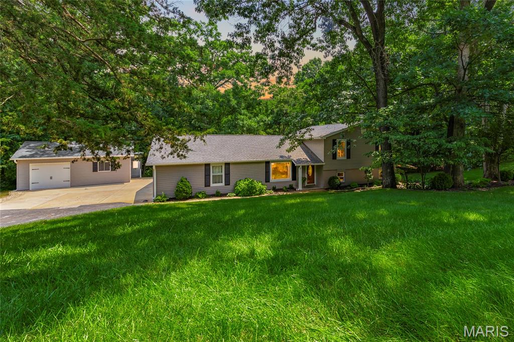 Stunning home sitting on a 3 acre lot with an outbuilding located in the sought after subdivision of Hickory Hill Farm in O Fallon! This home boasts 4 bedrooms, 2.5 bathrooms, over 2,300 square feet of living space. 

The 18 x 24 foot outbuilding is insulated and features 1 garage door, AC, central vacuum, 3 speed exhaust fan, storage in attic above with multiple ceiling access panels which open to the storage area, attached storage shed, and a she shed with AC, transom windows, and electric. 

The front door opens to the bright & airy living room with a vaulted ceiling and half inch engineered hardwood floors that flow throughout the main level. The living room opens to the formal dining room with a sliding glass door to the back deck. 

The updated kitchen boasts granite countertops, travertine tile backsplash, staggered cabinetry with crown molding, stainless steel appliances, new dishwasher (2026), newer stove with built-in air fryer, reverse osmosis with UV water filter, pantry, and dining area. 

The second level features the primary bedroom with a sliding glass door to the back deck, his and hers closets, Brazilian Tigerwood hardwood floors, and a barn door which opens to the updated primary bathroom (2024). Three additional bedrooms and a full hall bathroom with a newer vanity complete the second level. 

The lower level boasts a spacious family room with a wood burning fireplace and 2 sliding glass doors which open to the side patio. The bathroom with a new vanity (2026), office with a storage closet, and laundry room complete the lower level. 

Other highlights include: oversized 2 car garage with storage in the attic above and a work bench, newer carpeting, water softener, air humidifier, professional landscaping, drip irrigation to gardens, insulated attic, and a new roof (2024), new siding (2024), new gutters (2024), and new insulated garage doors (2024). 

Relax on the side patio or back deck and enjoy the private backyard! The flagstone patio features a SunSetter retractable awning. The 2 tier back deck boasts an attached cantilever umbrella and a hot tub which is included.

Enjoy the peaceful feel of country living without sacrificing the convenience of being in the heart of O'Fallon. Tucked away in a serene setting, you'll feel miles from the hustle and bustle while remaining just minutes from shopping, restaurants, parks, schools, and major highways!