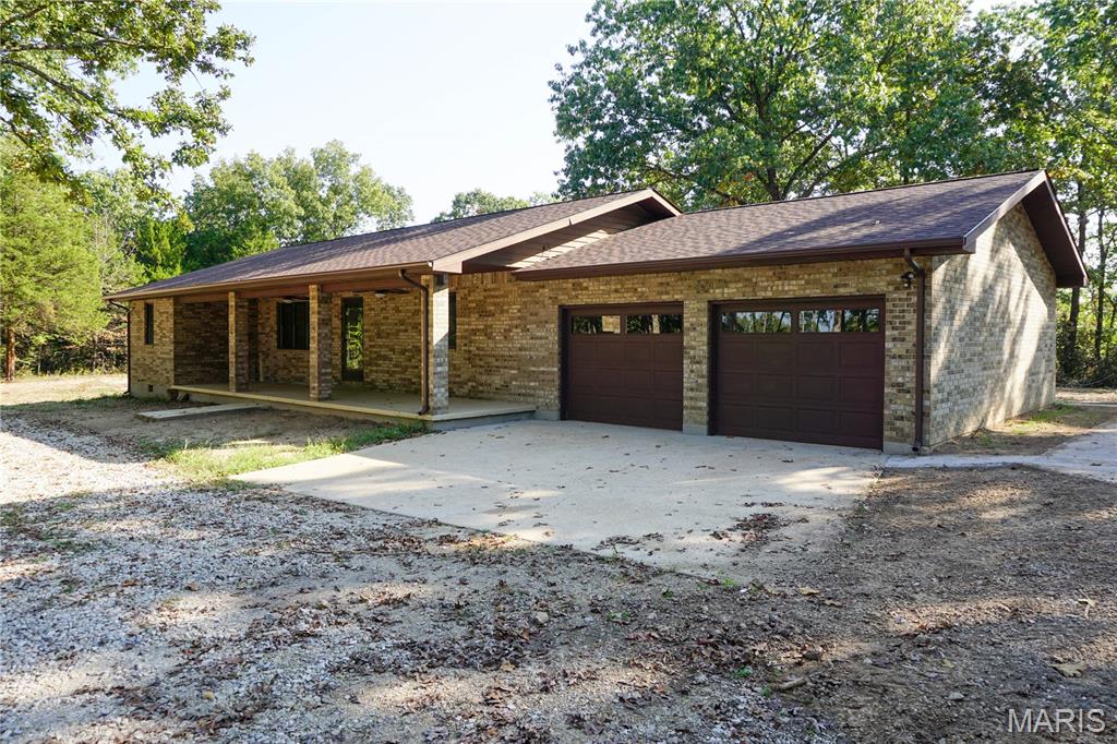 Escape to peace and privacy with this beautiful brick ranch home located in the Doolittle area, offering convenient access to I-44. Situated on 12.13 m/l acres, the home provides 1,800 m/l sq ft of comfortable living space and features solid wood interior doors, a welcoming living room, dining area, and a kitchen with island, oak cabinets, oven/range, exhaust fan, dishwasher, and refrigerator. There are 3 bedrooms, 2 full baths, and a spacious laundry room, along with a 2-car attached garage and circle drive for easy access. Relax on the covered front porch or enjoy quiet views from the large deck off the kitchen. The property is served by well water, septic sewer, and electric forced heat and air. A separate 30x40 m/l metal shop with two garage doors and electric provides excellent space for hobbies, storage, or equipment. Surrounded by nature, this property offers the serenity of the countryside while remaining conveniently close to town and interstate travel.